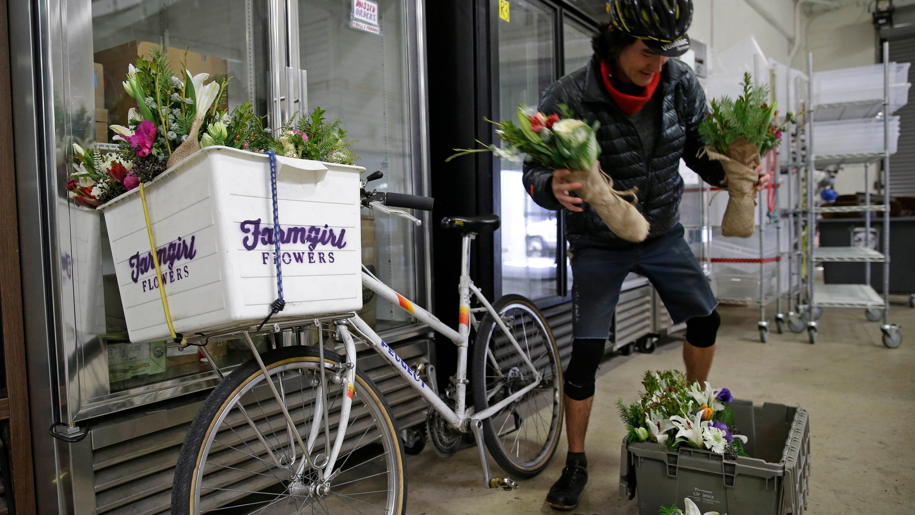 Ian Kizu-Blair, with Farmgirl Flowers, drops off a shipment to the Good Eggs warehouse in San Francisco. (AP Photo/Eric Risberg)