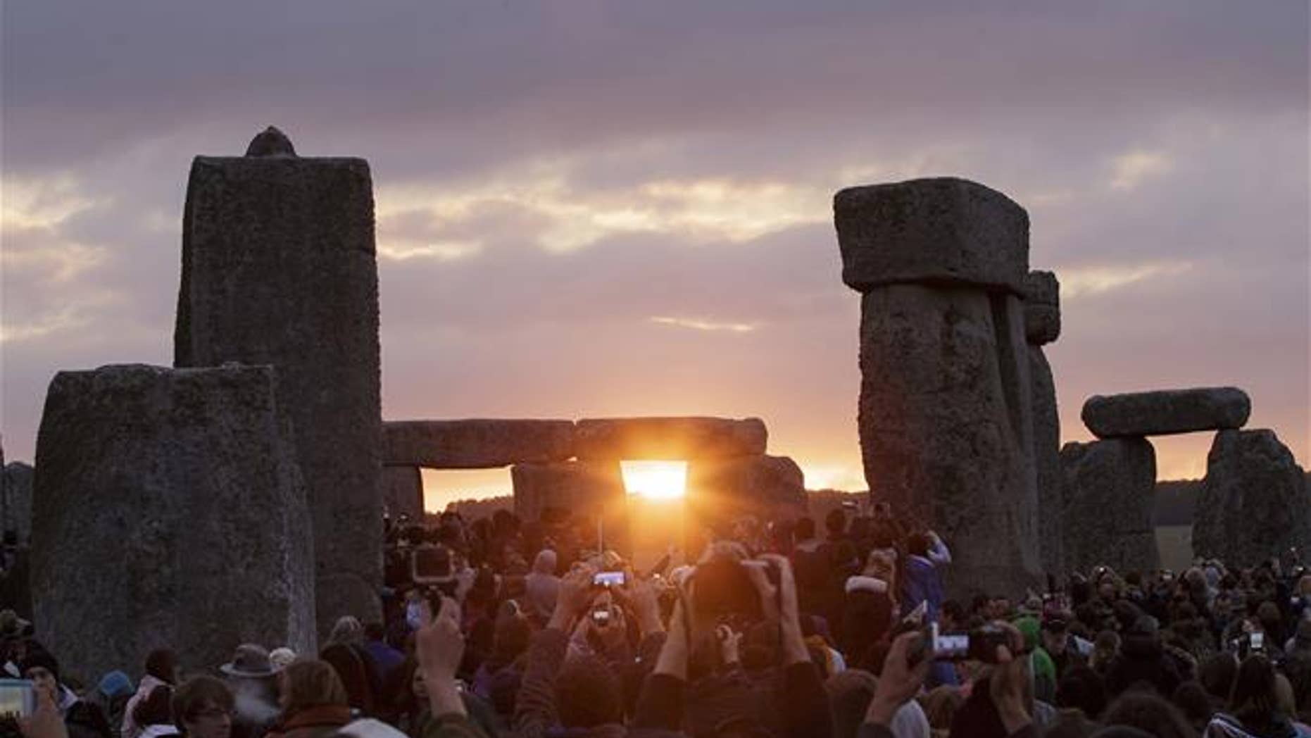 In this June 21, 2015, file photo, the sun rises as thousands of revelers gathered at the ancient stone circle Stonehenge to celebrate the Summer Solstice.