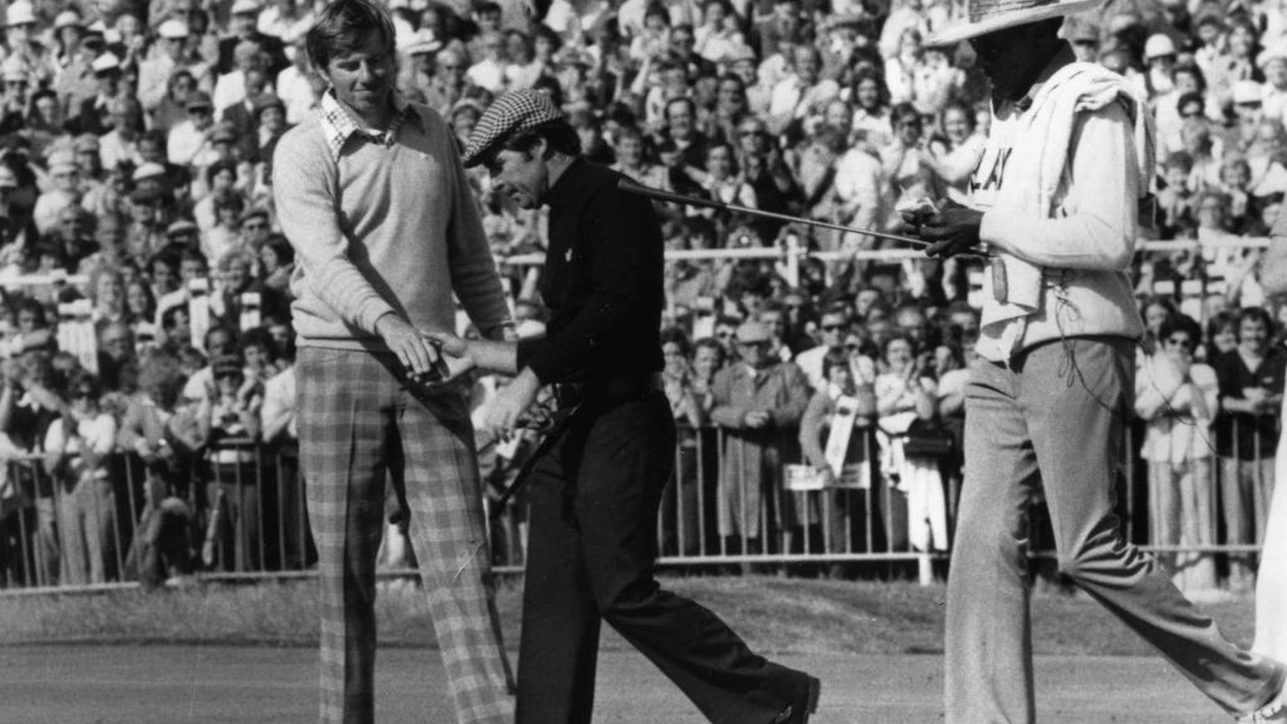 FILE - In this July 13, 1974, file photo, Gary Player, center, and Peter Oosterhuis shake hands after the final of the British Open Championship at Royal Lytham and St. Anne's in Lancashire, England. Oosterhuis, 67, said on Monday, June 29, 2015, that he has early onset Alzheimer's disease. (AP Photo, File)