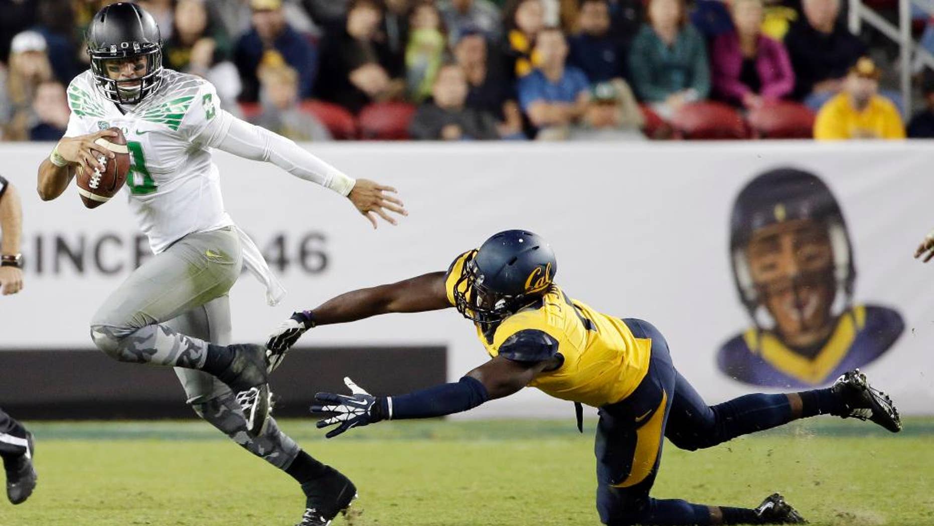 Oregon quarterback Marcus Mariota runs past California defensive end Jonathan Johnson during the second half of an NCAA college football game Friday, Oct. 24, 2014, in Santa Clara, Calif. (AP Photo/Marcio Jose Sanchez)
