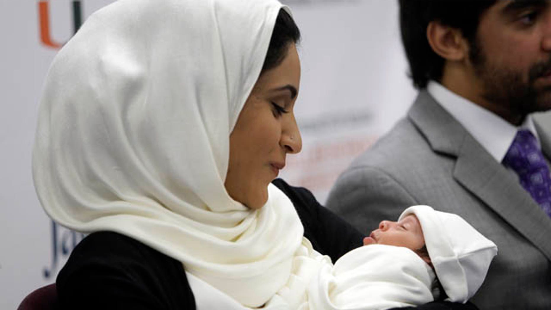 March 13, 2013: Fatema Al Ansari of Qatar, left, holds her baby Alkadi Alhayal, as her husband Khalifa Alhayal, right, looks on during a news conference at Jackson Memorial Hospital.