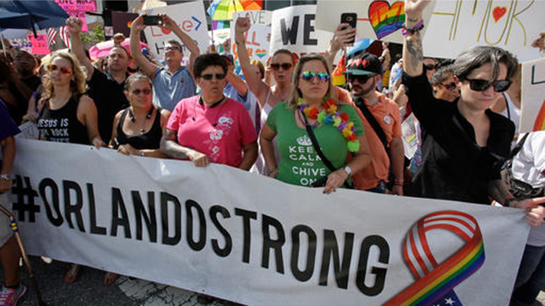 FILE- In this June 18, 2016 file photo, demonstrators show their support during the funeral service for Christopher Andrew Leinonen, one of the victims of the Pulse nightclub mass shooting, outside the Cathedral Church of St. Luke, in Orlando, Fla. Following the attack, other victims of mass shootings reached out to the survivors and their families to ensure that mistakes made with previous charity efforts were not repeated. (AP Photo/John Raoux, File)