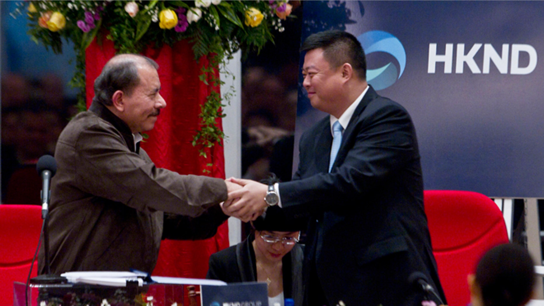 Nicaragua's President Daniel Ortega, left, and Chinese businessman Wang Jing shake hands before signing a concession agreement for the construction of a multibillion-dollar canal at the Casa de los Pueblos in Managua, Nicaragua, Friday, June 14, 2013. Legislation approved by a 61-25 vote in the National Assembly dominated by Ortega's Sandinista Front contains no specific route for the canal and virtually no details of its financing or economic viability, but it grants a Hong Kong-based company 50 years of exclusive rights to study the plan and build and operate a canal in exchange for Nicaragua receiving a minority share of any profits. (AP Photo/Esteban Felix)