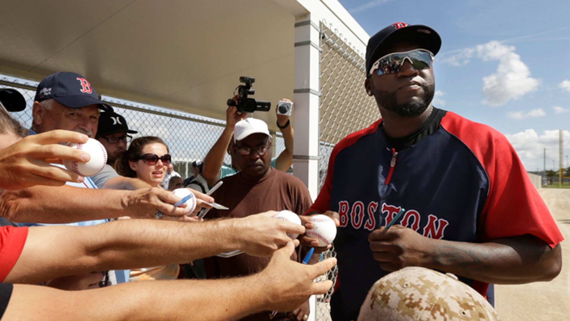 Boston Red Sox designated hitter David Ortiz signs autographs during spring training baseball practice, Sunday, Feb. 23, 2014, in Fort Myers, Fla. (AP Photo/Steven Senne)