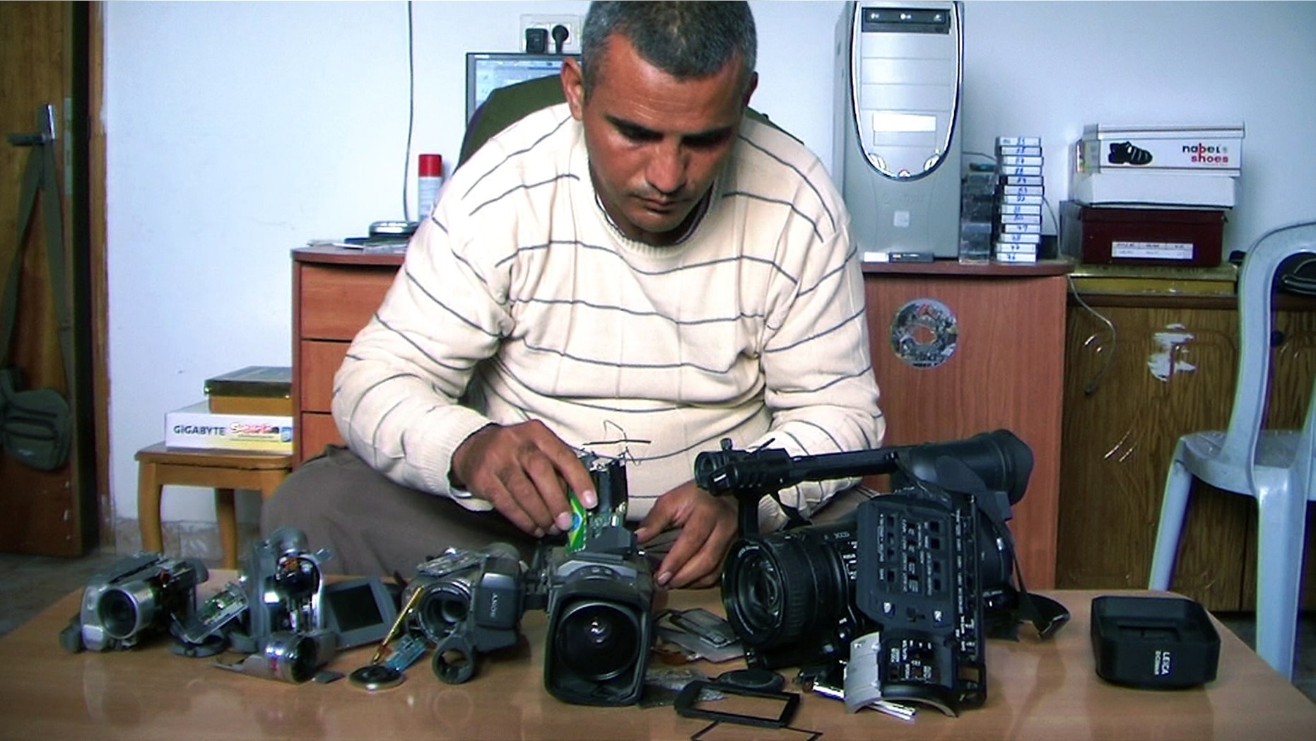 This undated publicity photo released by Kino Lorber, Inc. shows Co-director Emad Burnat with his five broken cameras.