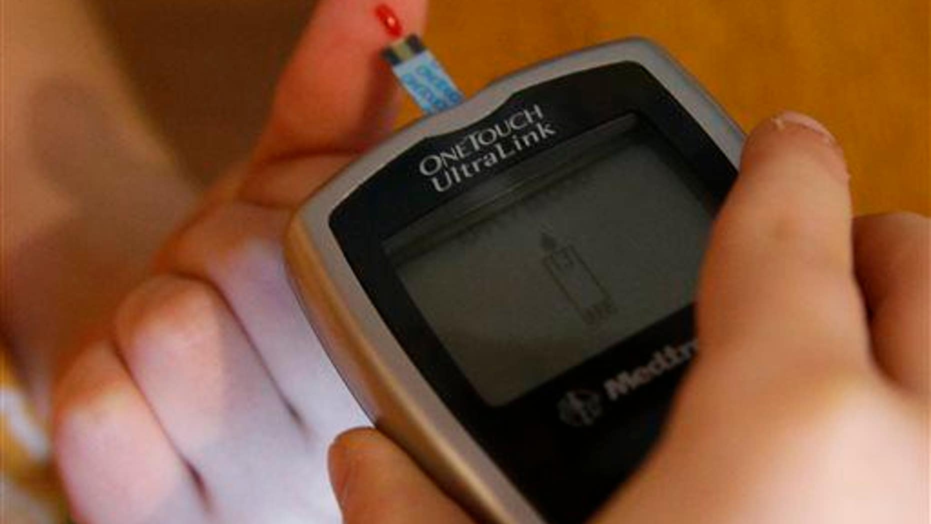 This file photo shows a diabetic pricking his finger to test his blood.