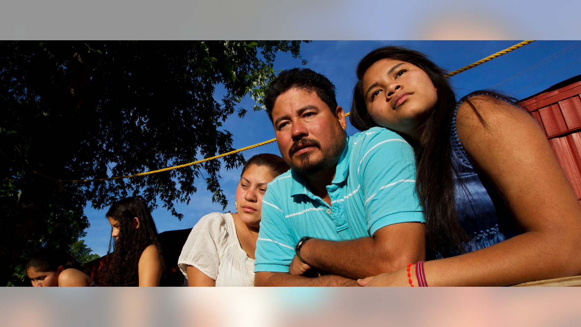 In this Thursday, April 13, 2012 photo, Diane Martell, 17, right, leans on her parents Maurcio and Guadalupe on the porch of their home in Bessemer, Ala. (AP Photo/Dave Martin)