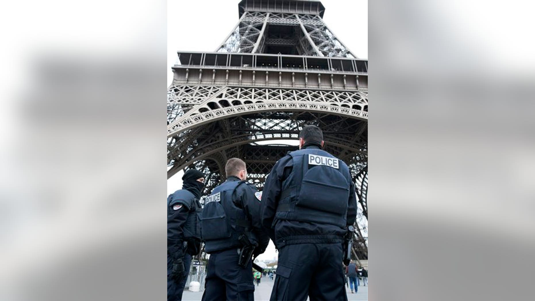 Police forces on patrol pass under the closed Eiffel Tower in Paris, France, Saturday, Nov. 14, 2015, one day after a killing spree orchestrated by ISIS that left 130 people dead. (AP Photo/Kamil Zihnioglu)