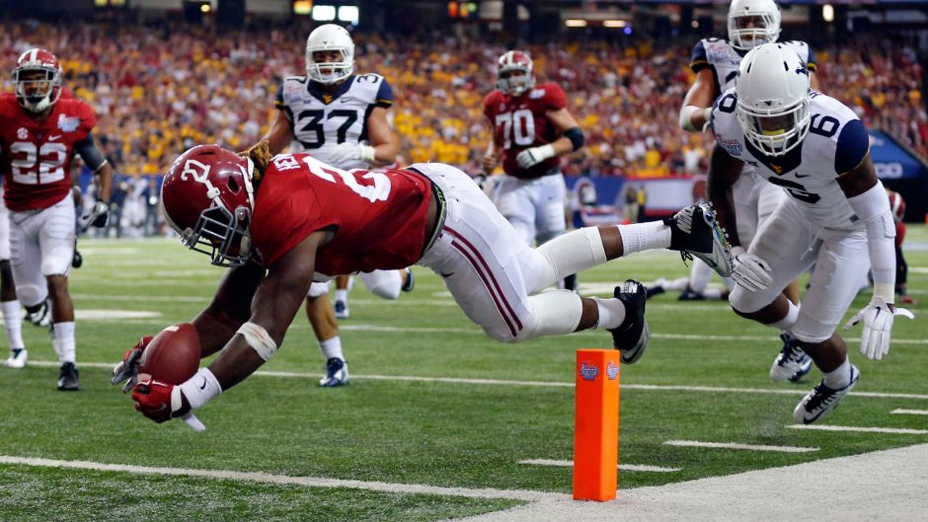 Aug 30, 2014; Atlanta, GA, USA; Alabama Crimson Tide running back Derrick Henry (27) dives for a touchdown against West Virginia Mountaineers cornerback Dravon Henry (6) during the third quarter of the 2014 Chick-fil-a kickoff game at Georgia Dome. Mandatory Credit: Paul Abell-USA TODAY Sports