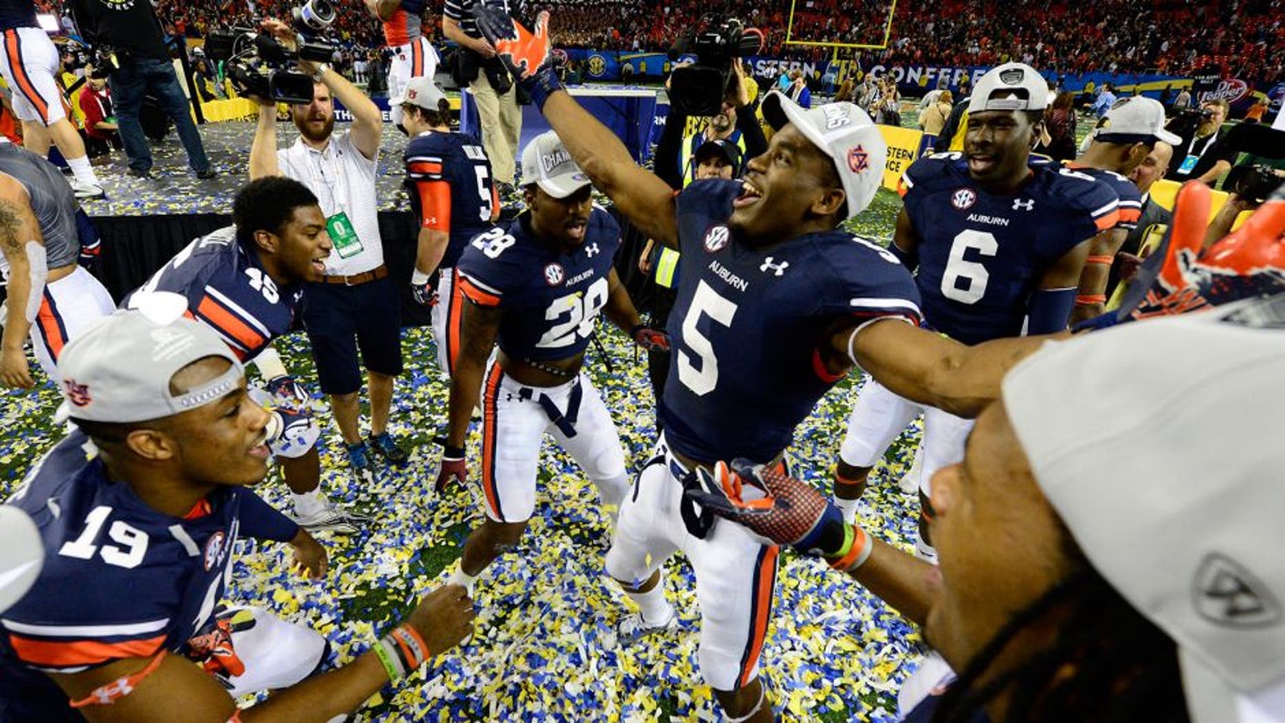 Dec 7, 2013; Atlanta, GA, USA; The Auburn Tigers play in confetti after defeating the Missouri Tigers in the 2013 SEC Championship game at Georgia Dome. Auburn won 59-42. Mandatory Credit: John David Mercer-USA TODAY Sports