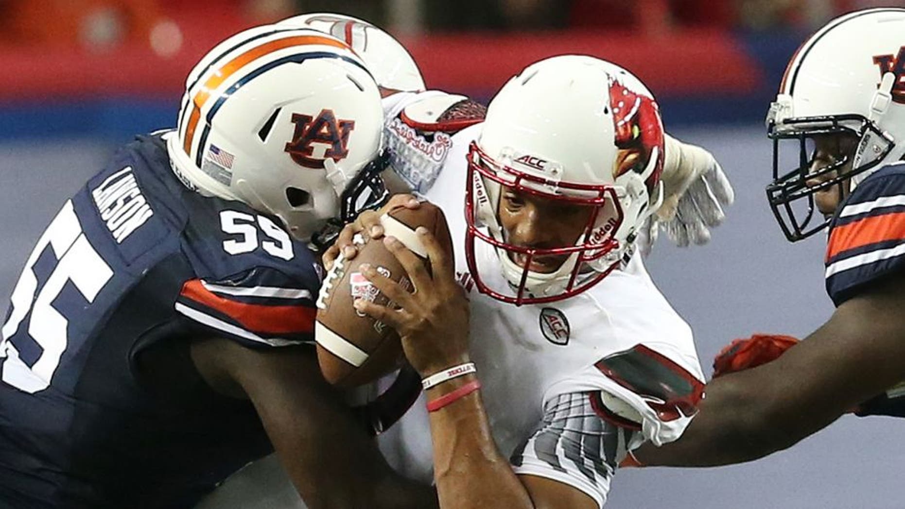 Auburn defensive lineman Carl Lawson (55) tackles Louisville quarterback Reggie Bonnafon (7) during the first half of an NCAA college football game, Saturday, Sept. 5, 2015, in Atlanta. (AP Photo/John Bazemore)
