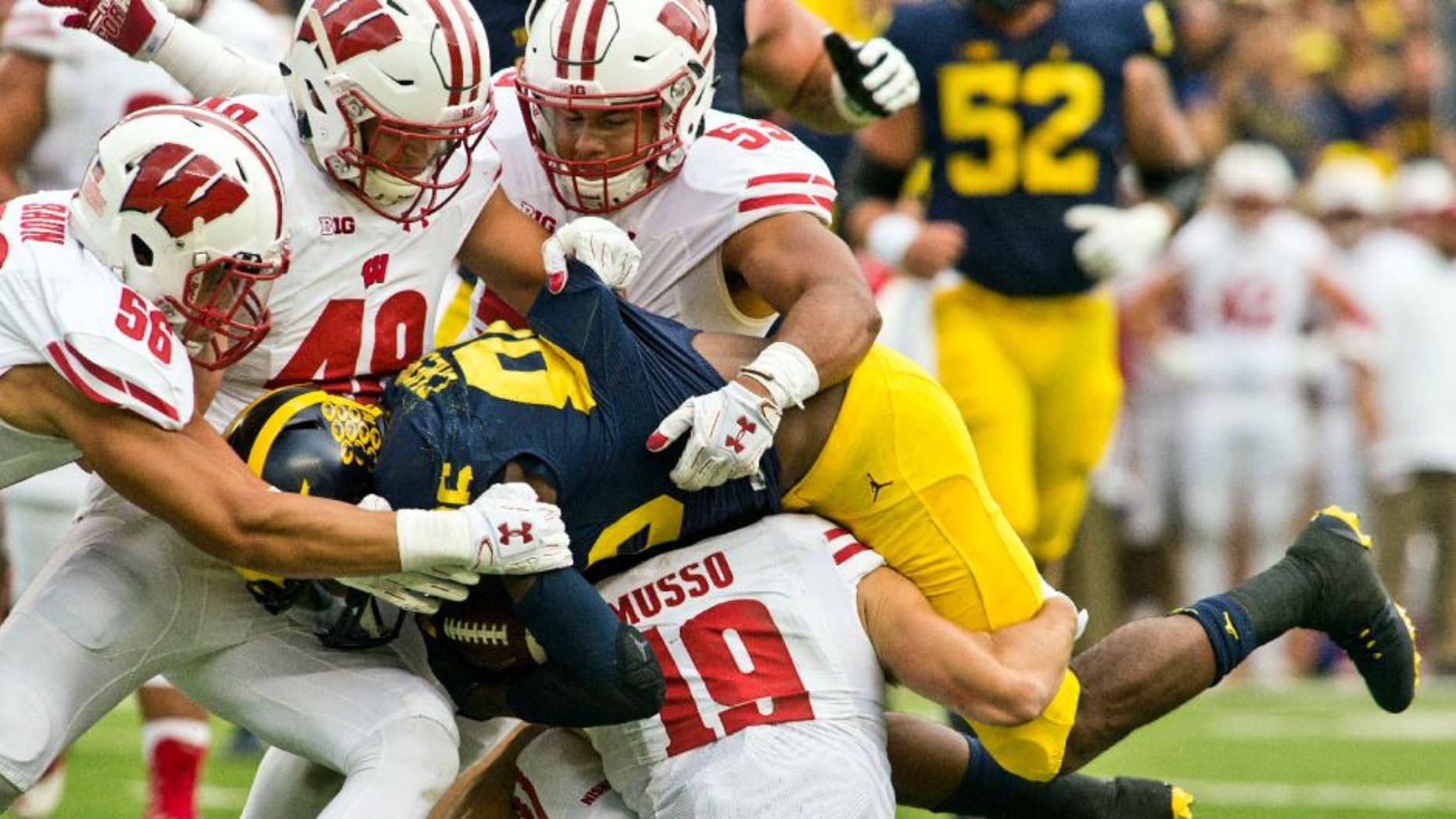 Michigan wide receiver Jehu Chesson, center, is gang-tackled by Wisconsin defenders Zack Baun, Jack Cichy, T.J. Edwards and Leo Musso in the first quarter.