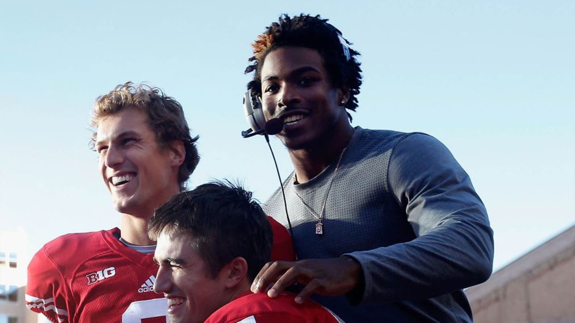 Corey Clement (top right) celebrates with quarterback Joel Stave (left) and Andrew Endicott during the final moments of a 28-3 win against the Troy Trojans at Camp Randall Stadium on September 19, 2015, in Madison, Wisconsin.
