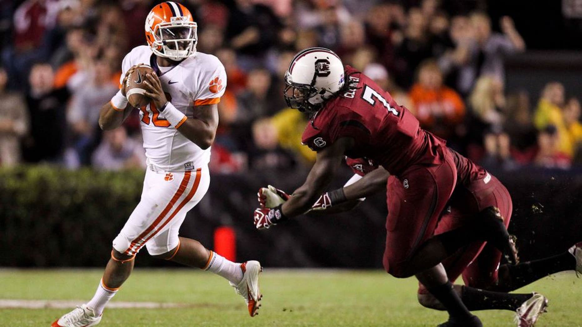November 26, 2011; Columbia, SC, USA; Clemson Tigers quarterback Tajh Boyd (10) scrambles away from South Carolina Gamecocks defensive end Jadeveon Clowney (7) in the third quarter of the game at the Williams-Brice Stadium. The Gamecocks beat the Tigers 34-13. Mandatory Credit: Daniel Shirey-USA TODAY Sports