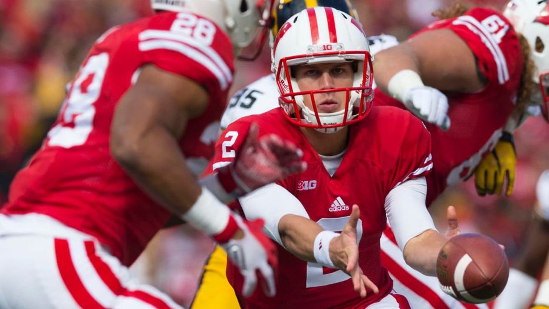 Wisconsin Badgers quarterback Joel Stave pitches the football to running back Taiwan Deal during the first quarter against the Iowa Hawkeyes at Camp Randall Stadium in Madison, Wis., on Saturday, Oct. 3, 2015.