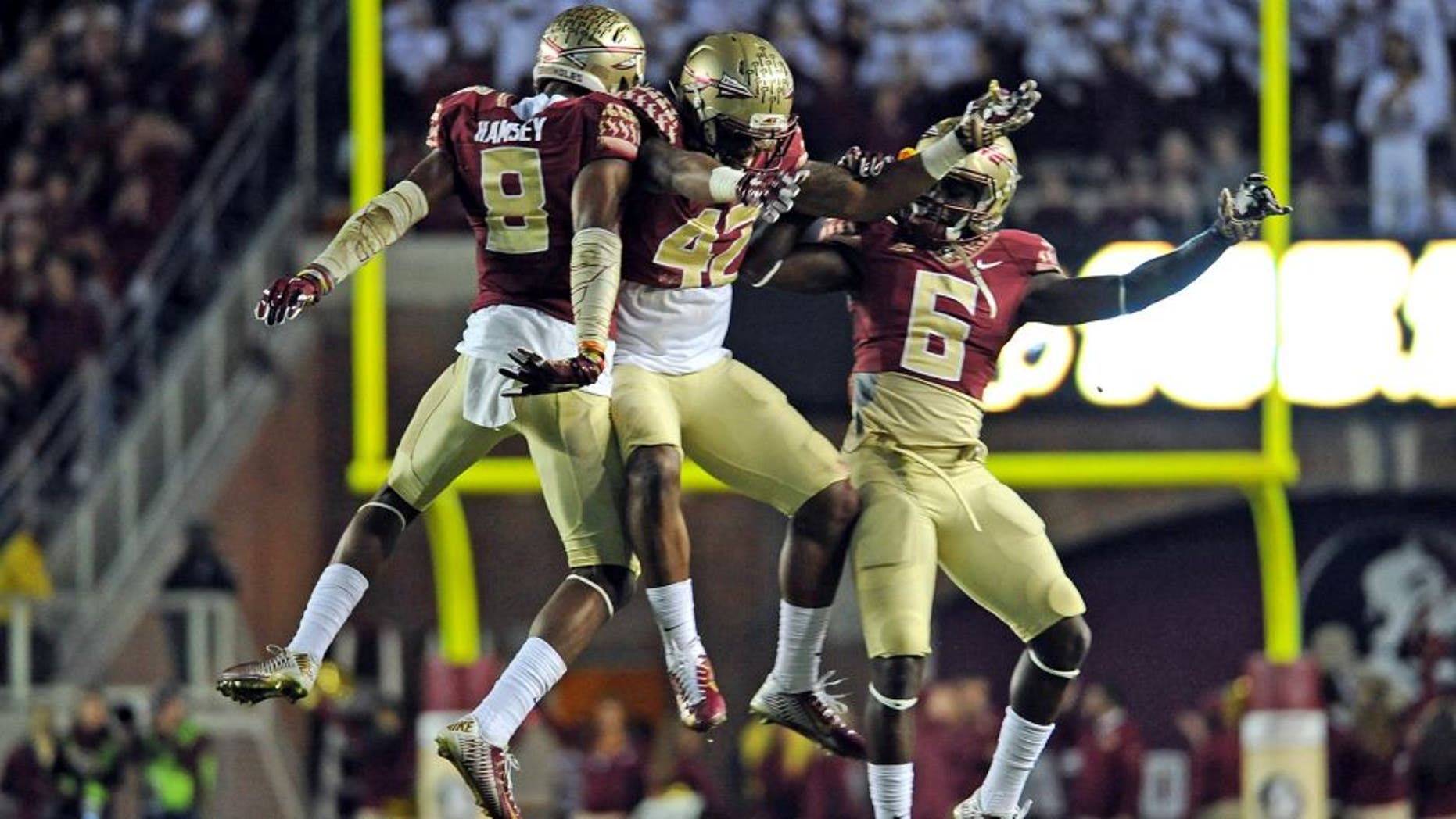 Nov 29, 2014; Tallahassee, FL, USA; Florida State Seminoles defensive back Jalen Ramsey (8), defensive back Lamarcus Brutus (42), and cornerback Nick Waisome (6) celebrate during the game against the Florida Gators at Doak Campbell Stadium. Mandatory Credit: Melina Vastola-USA TODAY Sports