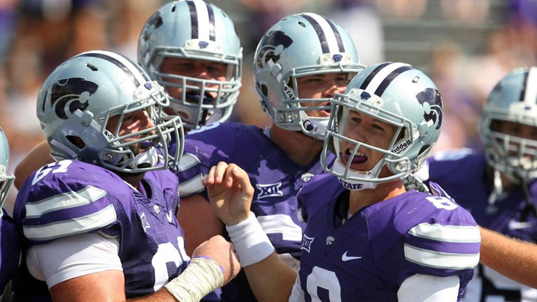 Sep 27, 2014; Manhattan, KS, USA; Kansas State Wildcats quarterback Joe Hubener (8) is congratulated by teammates following a touchdown in a 58-28 win against the UTEP Miners at Bill Snyder Family Stadium. Mandatory Credit: Scott Sewell-USA TODAY Sports