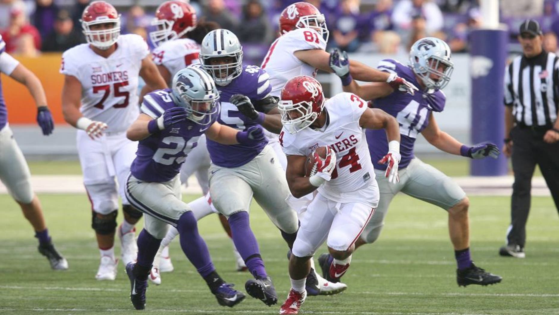 Oct 17, 2015; Manhattan, KS, USA; Oklahoma Sooners running back Daniel Brooks (34) is chased by Kansas State Wildcats defensive back Sean Newlan (29) during the Sooners 55-0 win at Bill Snyder Family Football Stadium. Mandatory Credit: Scott Sewell-USA TODAY Sports
