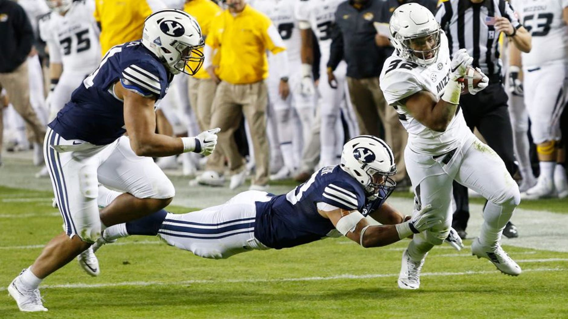 Missouri running back Russell Hansbrough, right, slips past BYU linebackers Jherremya Leuta-Douyere, center, and Harvey Langi, left, in the first half of a college football game at Arrowhead Stadium, Saturday, Nov. 14, 2015, in Kansas City, Mo. (AP Photo/Colin E. Braley)