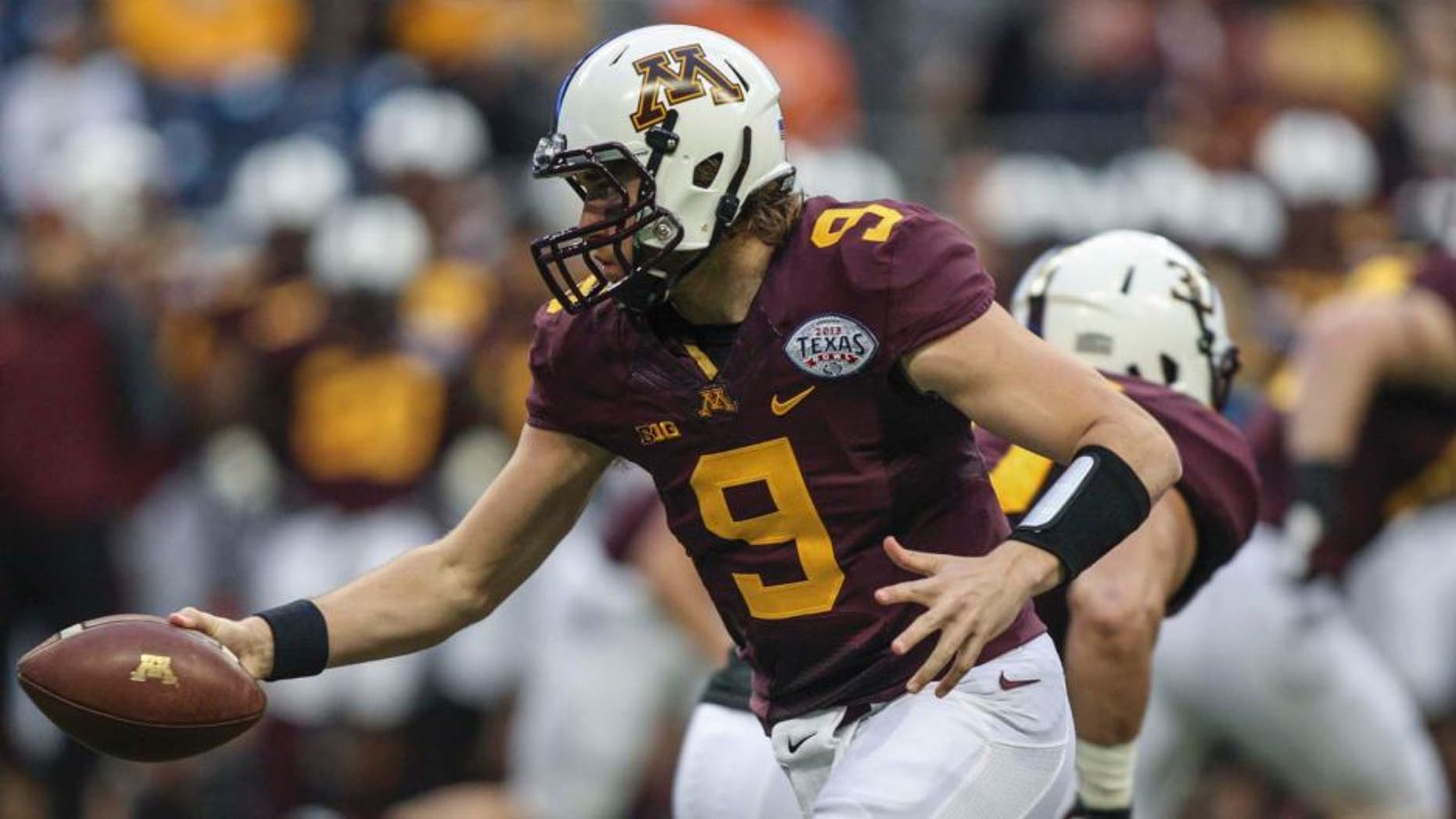 Dec 27, 2013; Houston, TX, USA; Minnesota Golden Gophers quarterback Philip Nelson (9) hands the ball off during the first quarter of the Texas Bowl against the Syracuse Orange at Reliant Stadium . Mandatory Credit: Troy Taormina-USA TODAY Sports