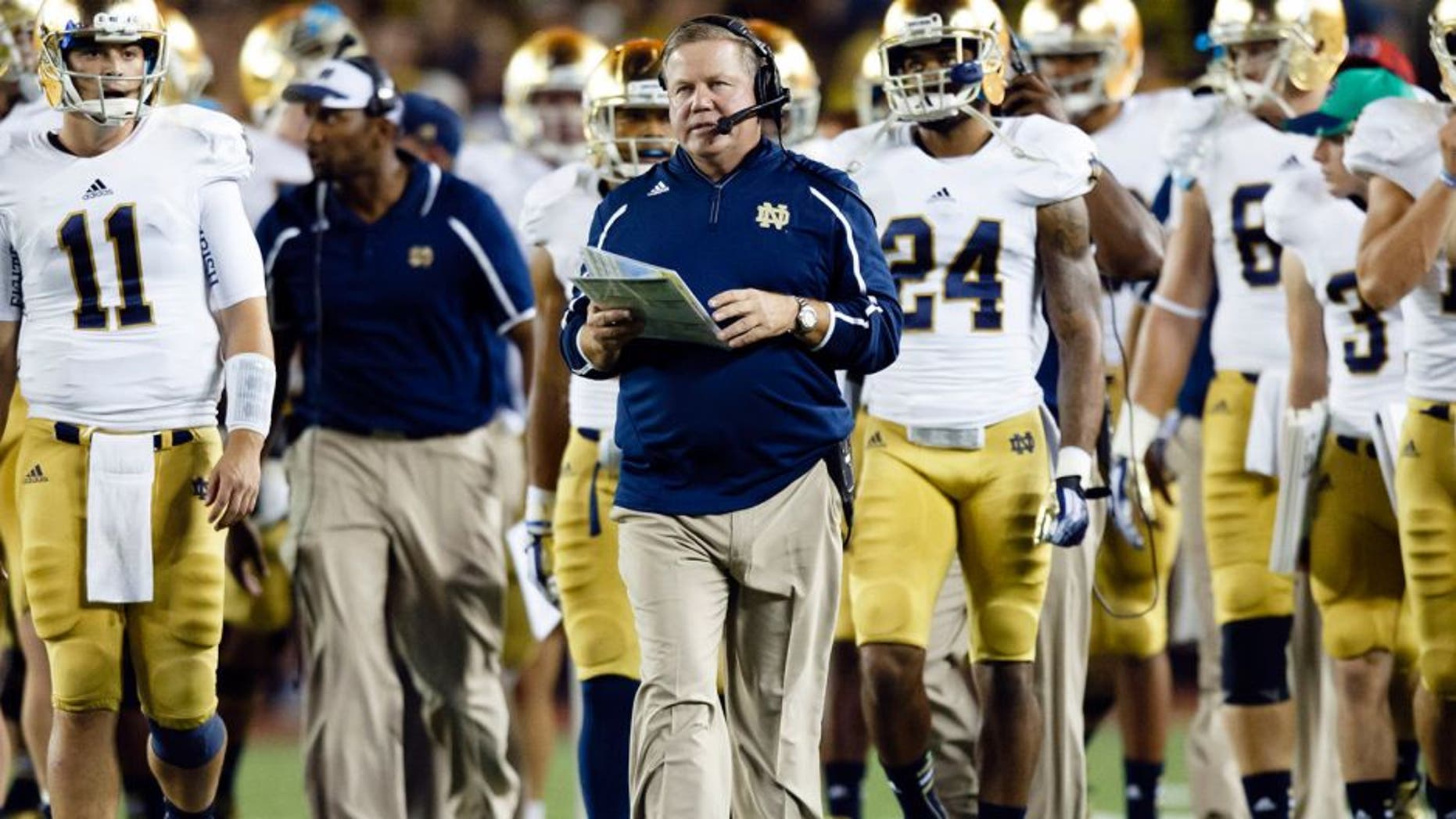Sep 7, 2013; Ann Arbor, MI, USA; Notre Dame Fighting Irish head coach Brian Kelly (center) leads the team down the field during the timeout between the third and forth quarters against the Michigan Wolverines at Michigan Stadium. Mandatory Credit: Rick Osentoski-USA TODAY Sports