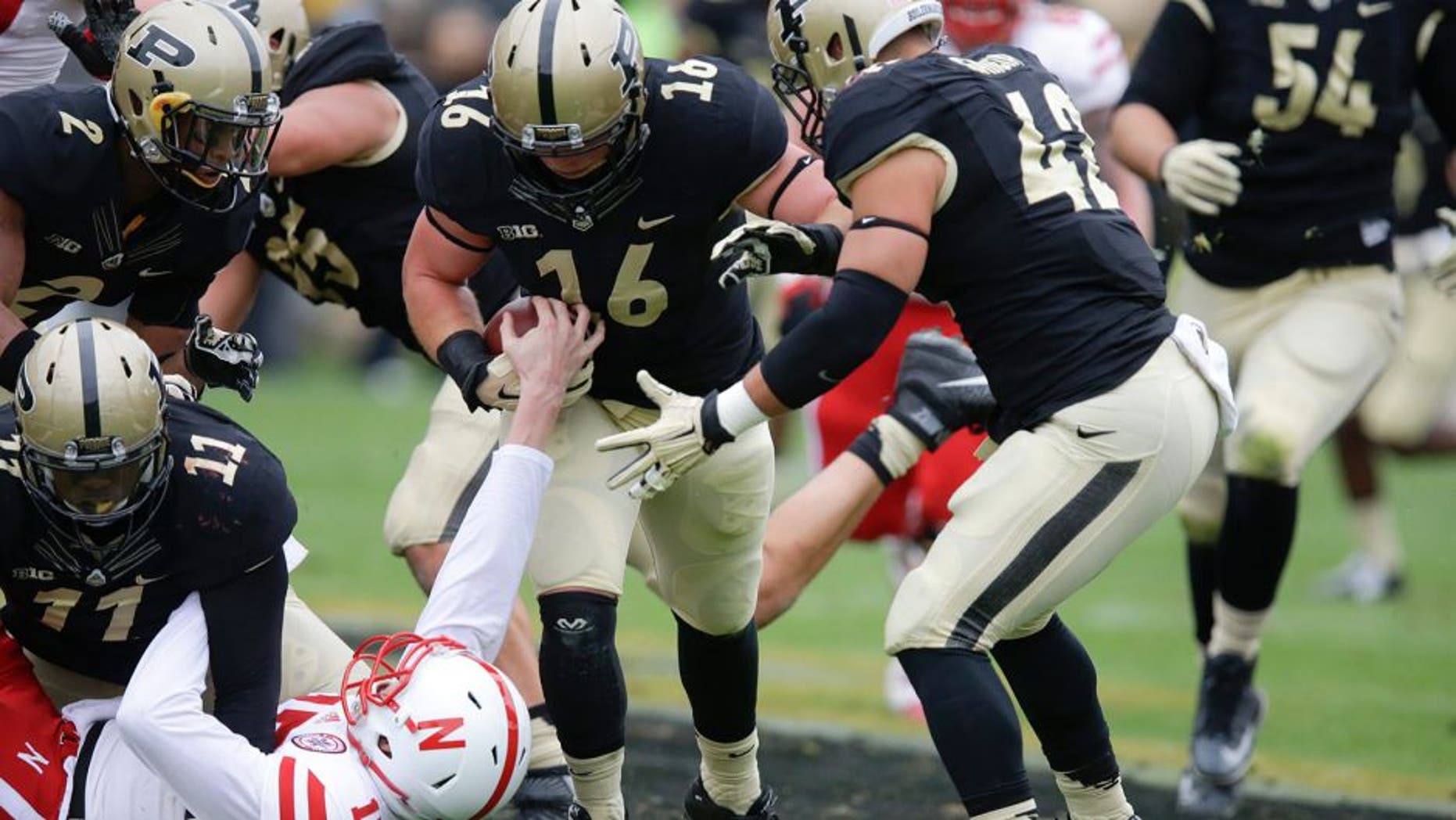 Nebraska quarterback Ryker Fyfe (17) tries to strip the ball from Purdue linebacker Garrett Hudson (16) after Hudson recovered a fumble during the first half of an NCAA college football game in West Lafayette, Ind., Saturday, Oct. 31, 2015. (AP Photo/Michael Conroy)