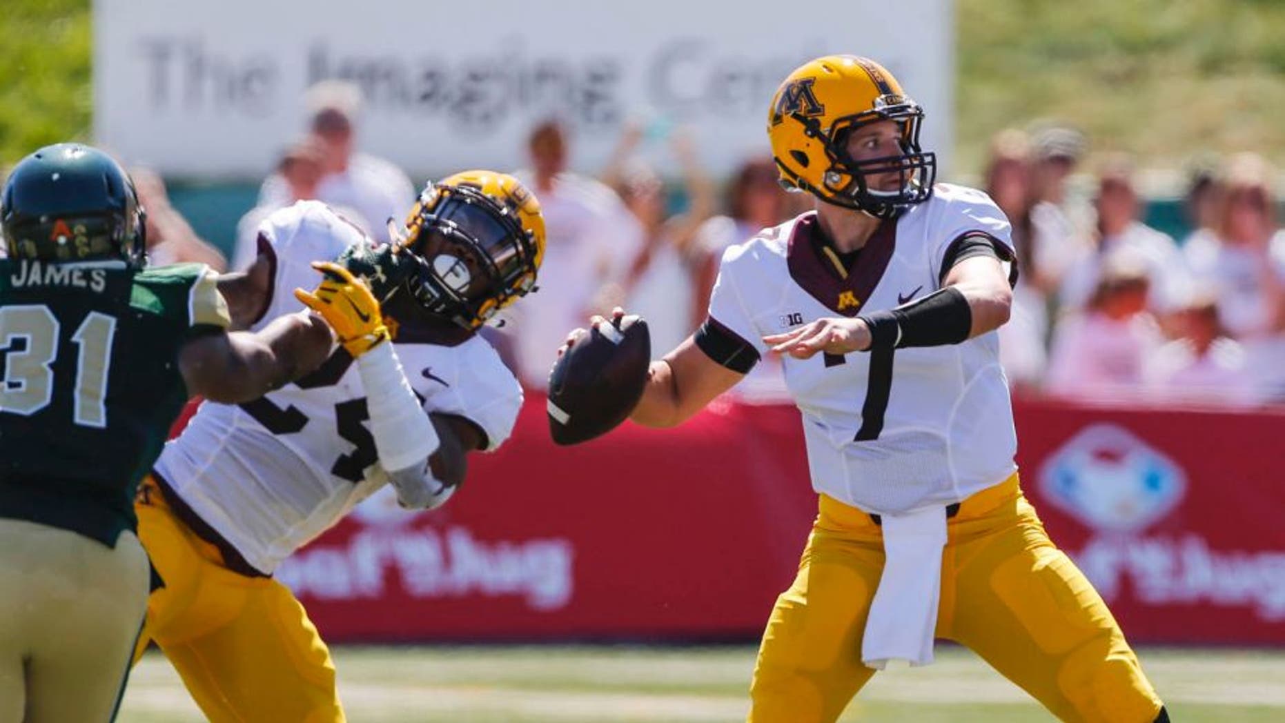 Minnesota Golden Gophers quarterback Mitch Leidner is protected by teammate Rodney Smith against Colorado State Rams linebacker Cory James during the first quarter at Sonny Lubick Field at Hughes Stadium in Fort Collins, Colo., on Sunday, Sept. 12, 2015.
