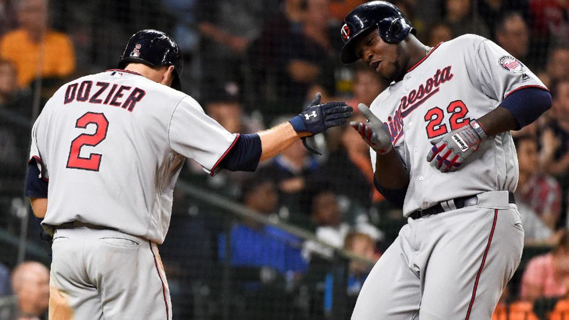 Minnesota Twins' Miguel Sano and Brian Dozier celebrate their runs scored off of a two-run triple by Byung Ho Park in the fifth inning of a baseball game against the Houston Astros.