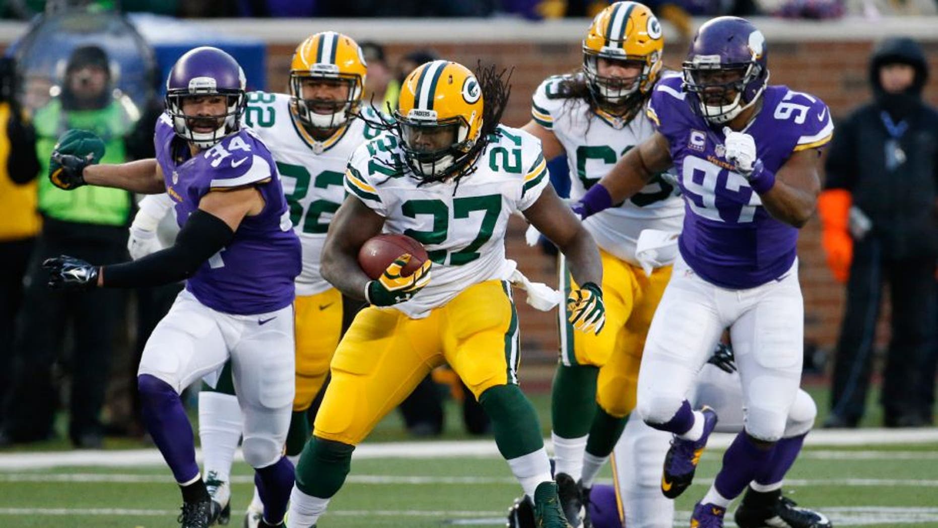 Green Bay Packers running back Eddie Lacy (27) runs past Minnesota Vikings strong safety Andrew Sendejo (34) an defensive end Everson Griffen (97) during the first half of an NFL football game in Minneapolis, Sunday, Nov. 22, 2015.