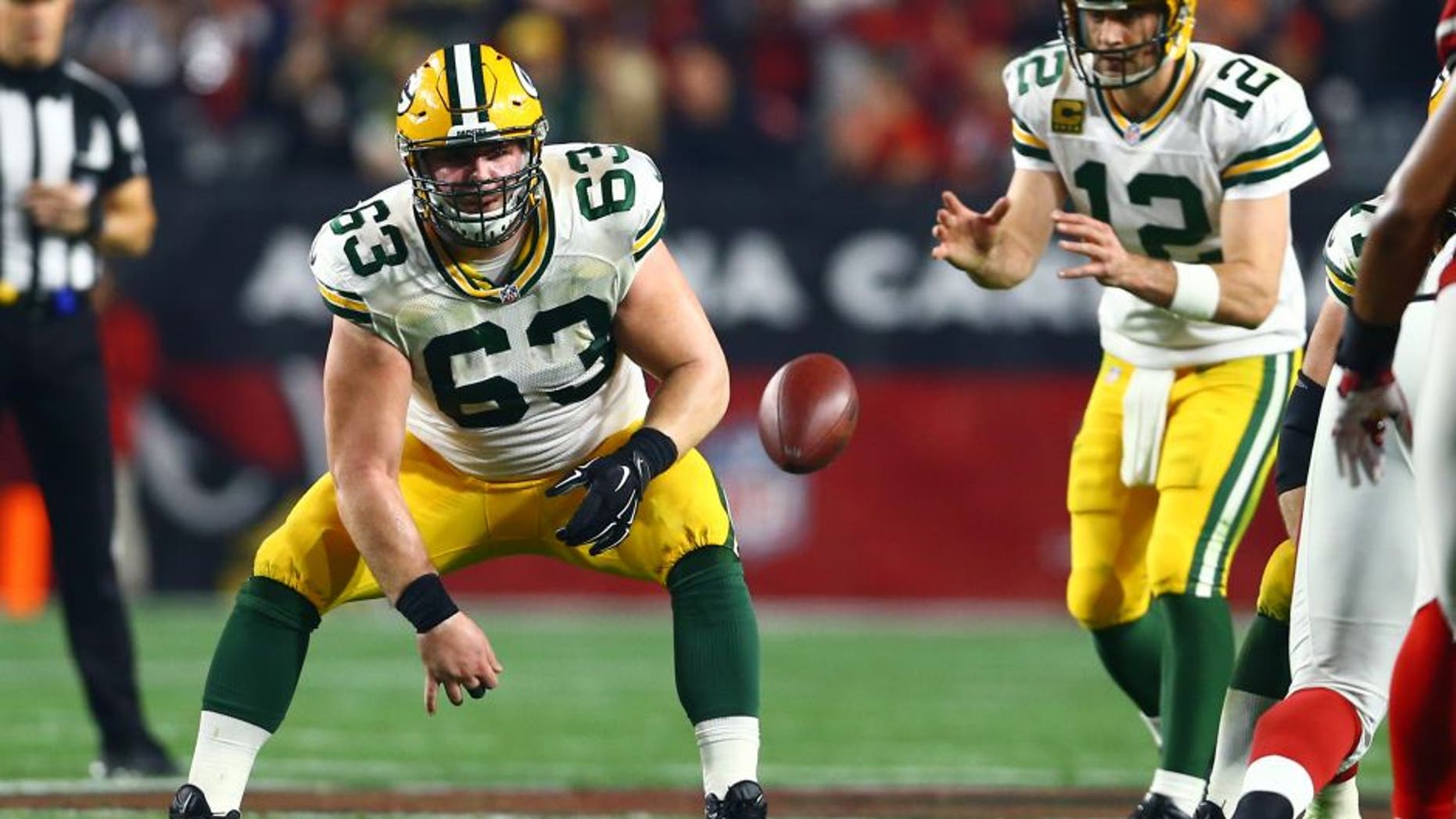 Jan 16, 2016; Glendale, AZ, USA; Green Bay Packers center Corey Linsley (63) snaps the ball to quarterback Aaron Rodgers (12) against the Arizona Cardinals in the first quarter of a NFC Divisional round playoff game at University of Phoenix Stadium. Mandatory Credit: Mark J. Rebilas-USA TODAY Sports