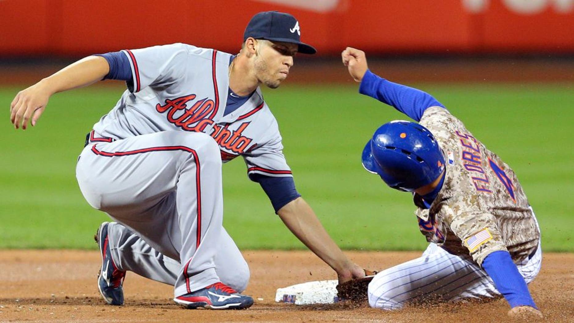 Sep 21, 2015; New York City, NY, USA; Atlanta Braves shortstop Andrelton Simmons (19) tags out New York Mets shortstop Wilmer Flores (4) on a steal attempt during the second inning at Citi Field. Mandatory Credit: Brad Penner-USA TODAY Sports