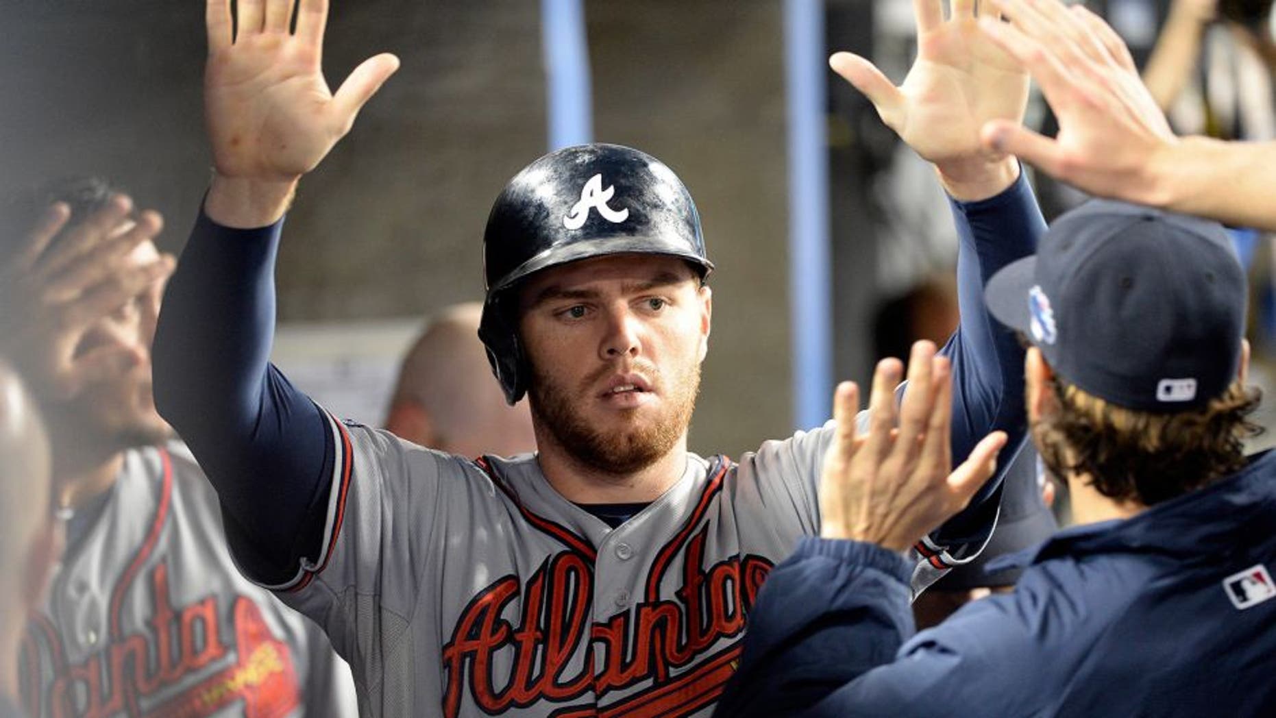 October 7, 2013; Los Angeles, CA, USA; Atlanta Braves first baseman Freddie Freeman (5) celebrates after he scores a run in the fourth inning against the Los Angeles Dodgers in game four of the National League divisional series playoff baseball game at Dodger Stadium. Mandatory Credit: Richard Mackson-USA TODAY Sports