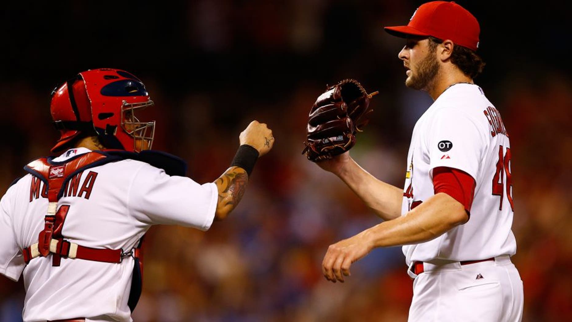 St. Louis Cardinals catcher Yadier Molina, left, celebrates with relief pitcher Kevin Siegrist after defeating the Kansas City Royals in a baseball game Friday, June 12, 2015, in St. Louis. (AP Photo/Billy Hurst)