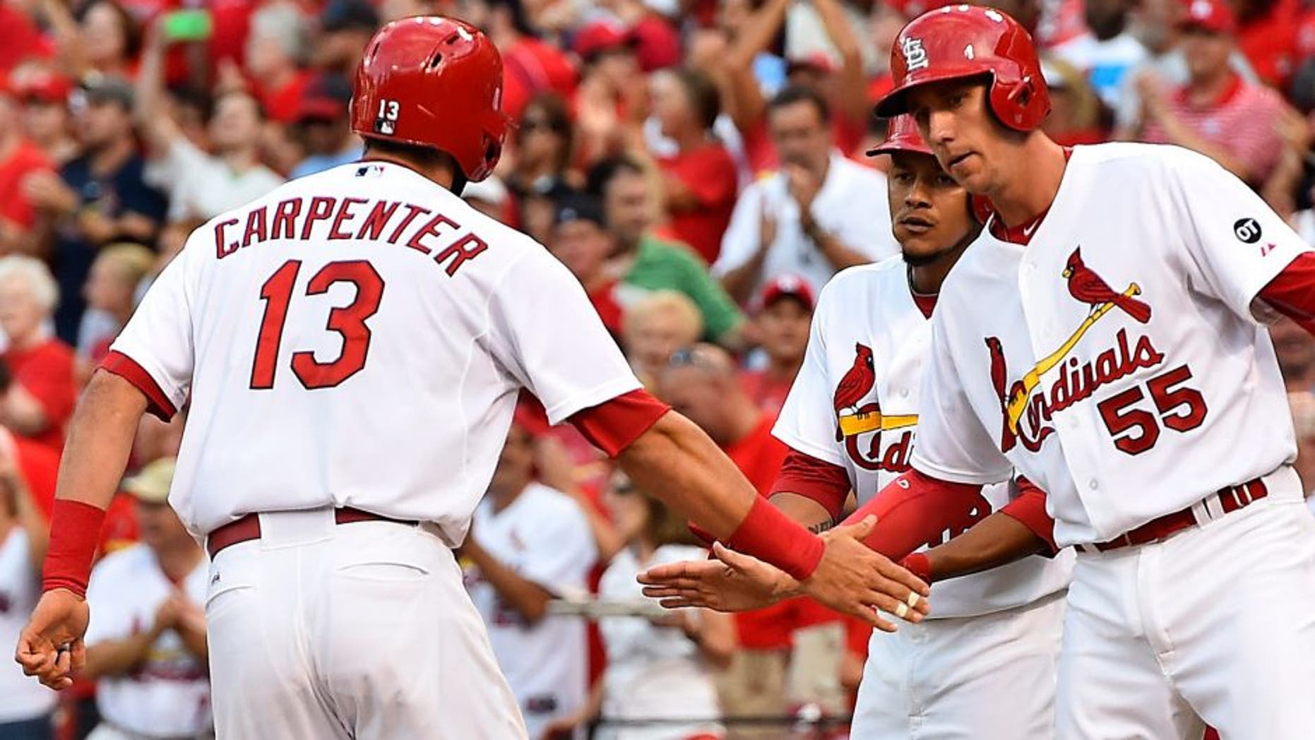Jul 30, 2015; St. Louis, MO, USA; St. Louis Cardinals third baseman Matt Carpenter (13) celebrates with teammates after hitting a three-run home run off of Colorado Rockies starting pitcher Chris Rusin (not pictured) in the second inning at Busch Stadium. Mandatory Credit: Jasen Vinlove-USA TODAY Sports