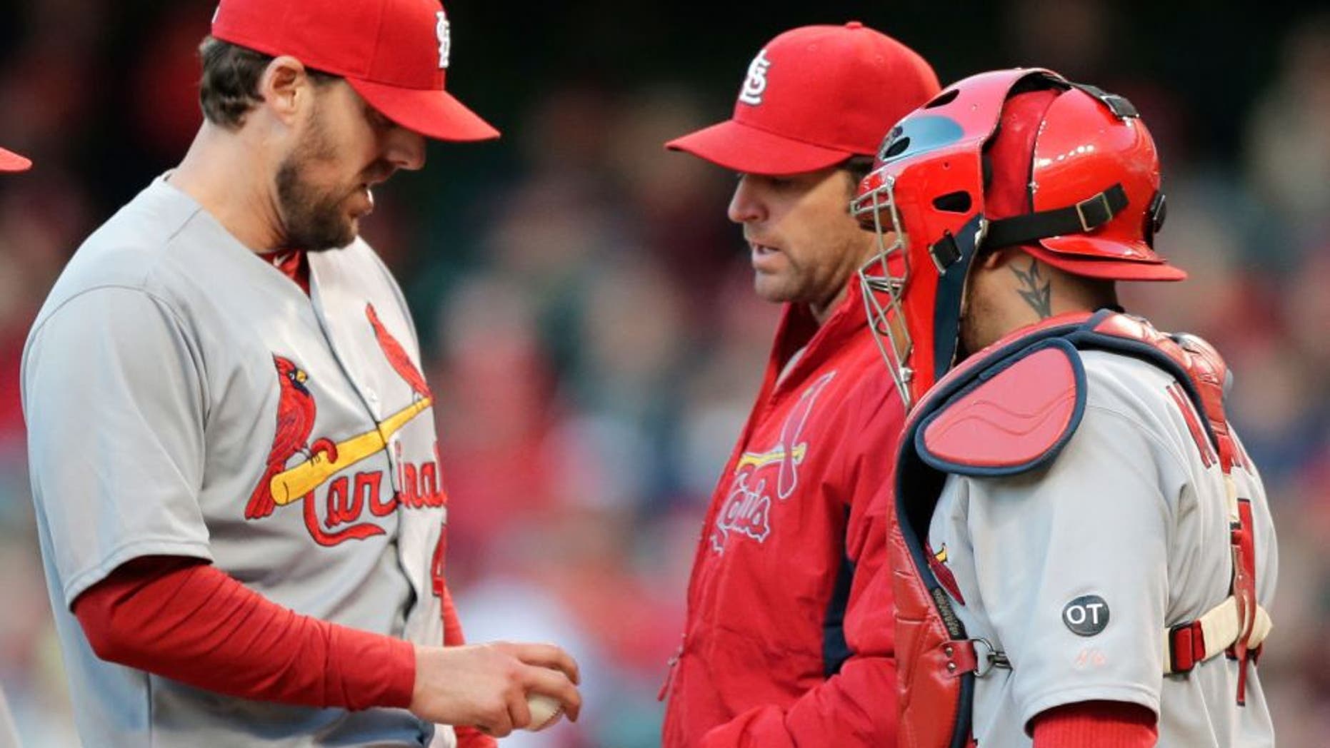 St. Louis Cardinals starting pitcher John Lackey, left, hands the ball off to manager Mike Matheny, center, as catcher Yadier Molina watches in the sixth inning of a baseball game against the Cleveland Indians, Wednesday, May 13, 2015, in Cleveland. Lackey pitched 5 1/3 innings and gave up five hits and two runs. (AP Photo/Tony Dejak)