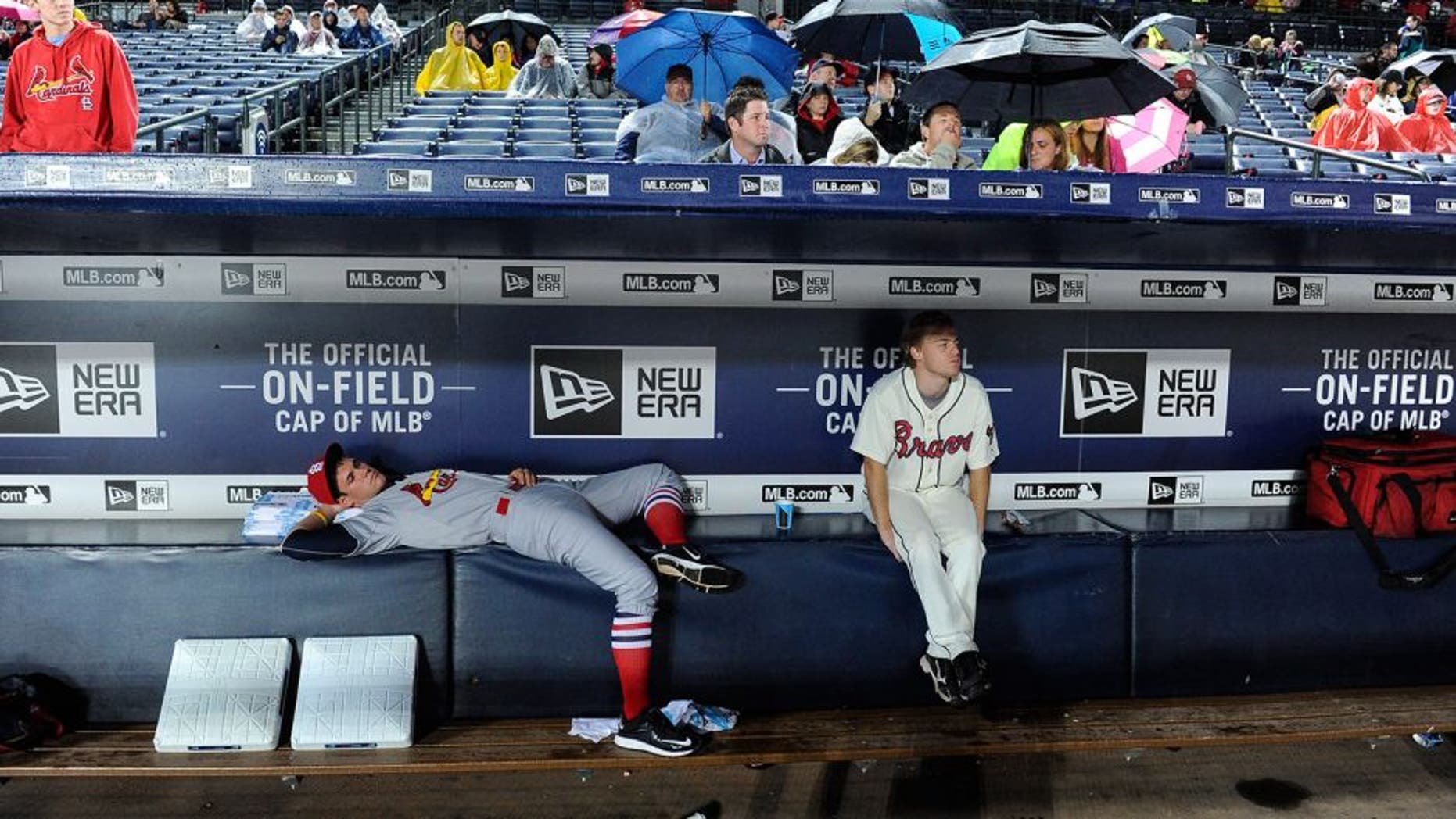 Bat boys wait out a weather-delayed start to the Atlanta Braves against the St. Louis Cardinals baseball game, Saturday, Oct. 3, 2015, in Atlanta. (AP Photo/John Amis)