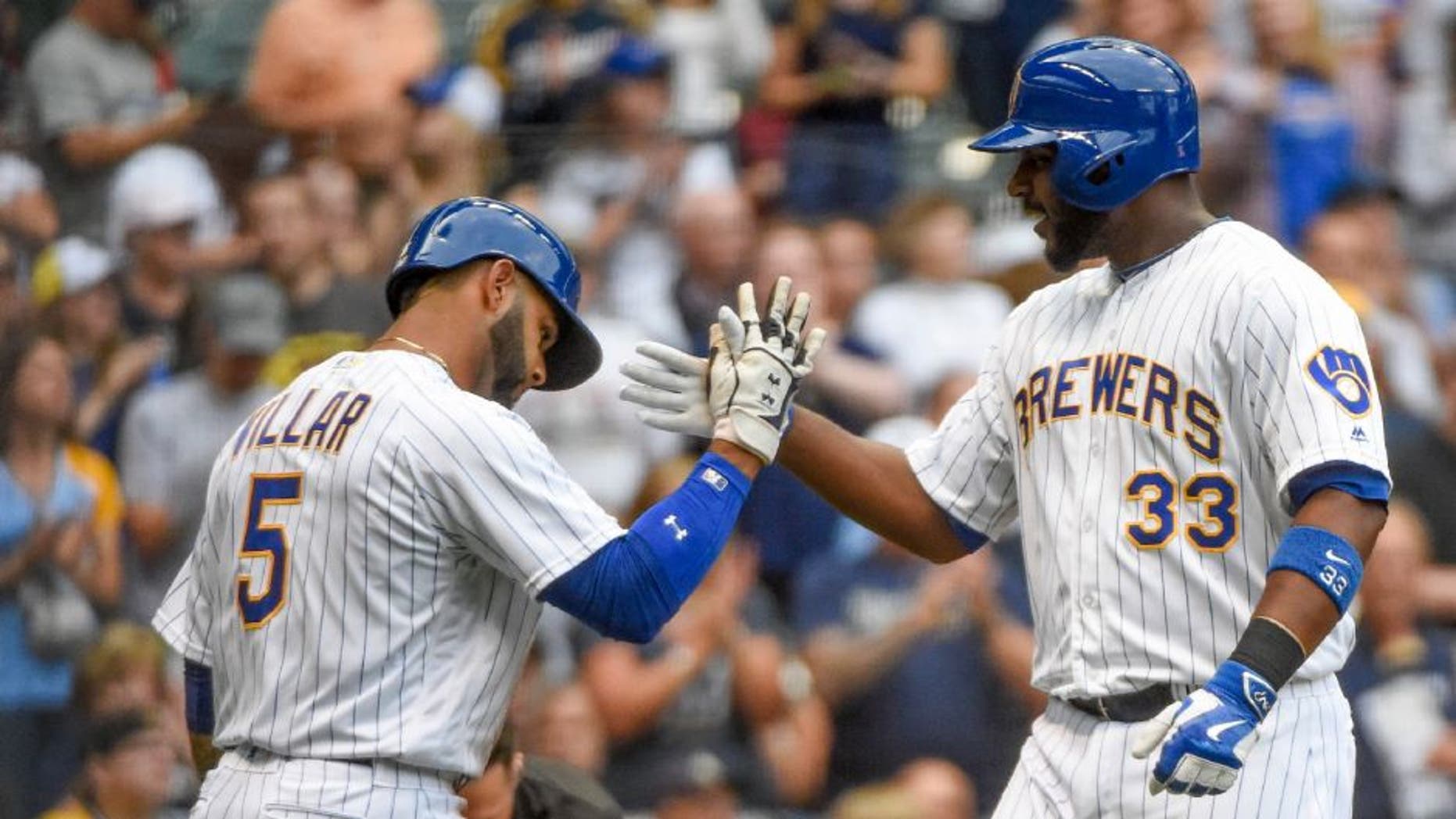 Milwaukee Brewers first baseman Chris Carter, right, is greeted by Jonathan Villar after hitting a two-run home run during the first inning against the Pittsburgh Pirates on Friday, July 29.
