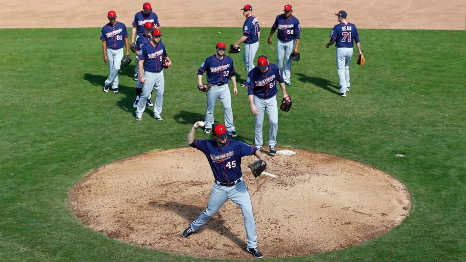 Minnesota Twins pitcher Phil Hughes runs a drill as teammates watch during a spring training baseball workout in Fort Myers, Fla., Monday, Feb. 22, 2016.