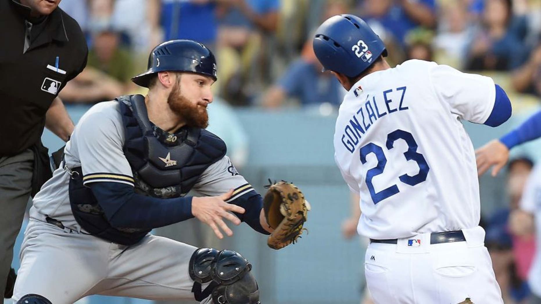 Milwaukee Brewers catcher Jonathan Lucroy tags out Los Angeles Dodgers first baseman Adrian Gonzalez in the second inning at Dodger Stadium in Los Angeles on June 18, 2016.