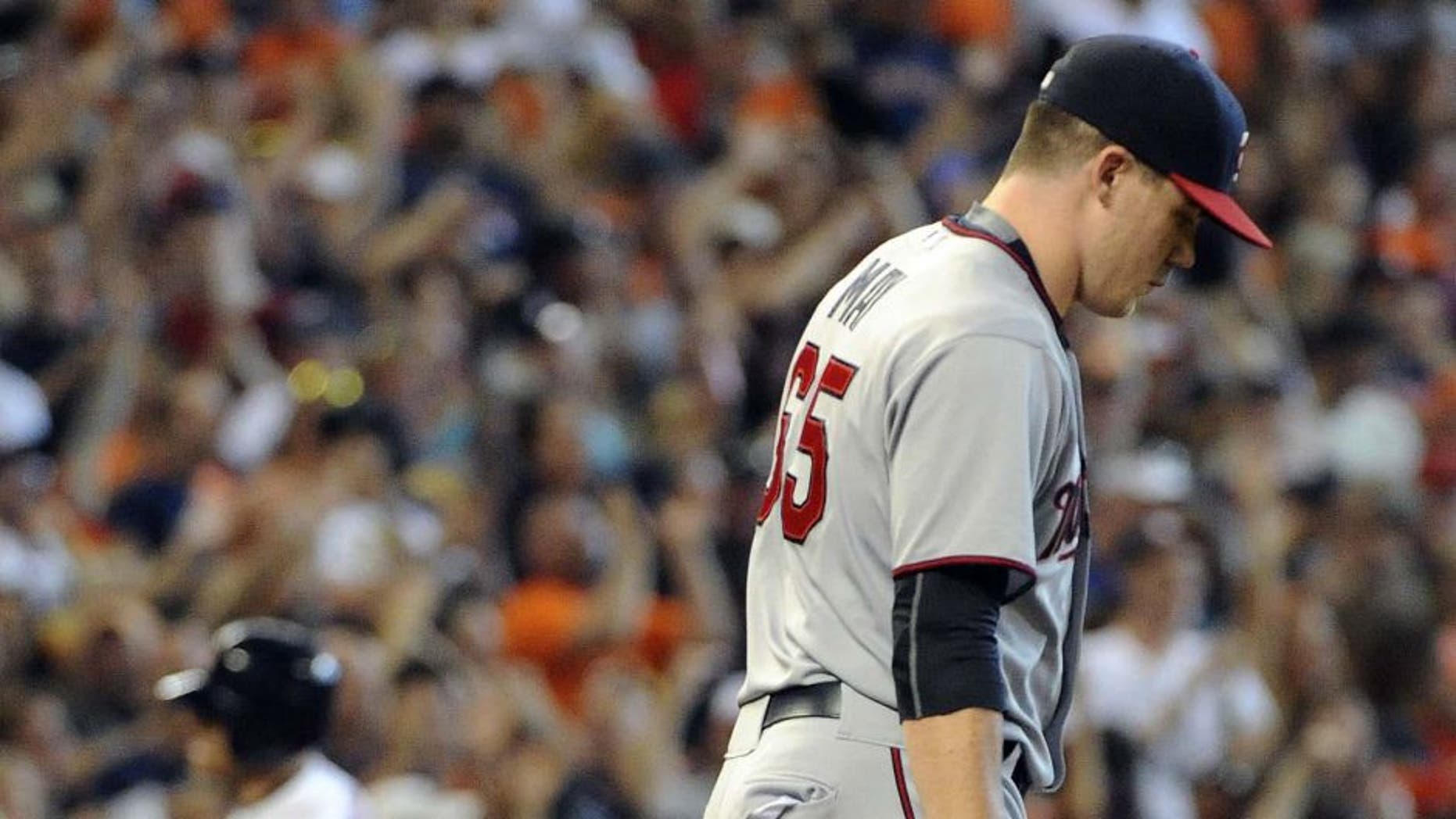Minnesota Twins relief pitcher Trevor May walks back to the mound as Jed Lowrie rounds third base after hitting a grand slam in the seventh inning Sunday, Sept. 6, 2015, in Houston.
