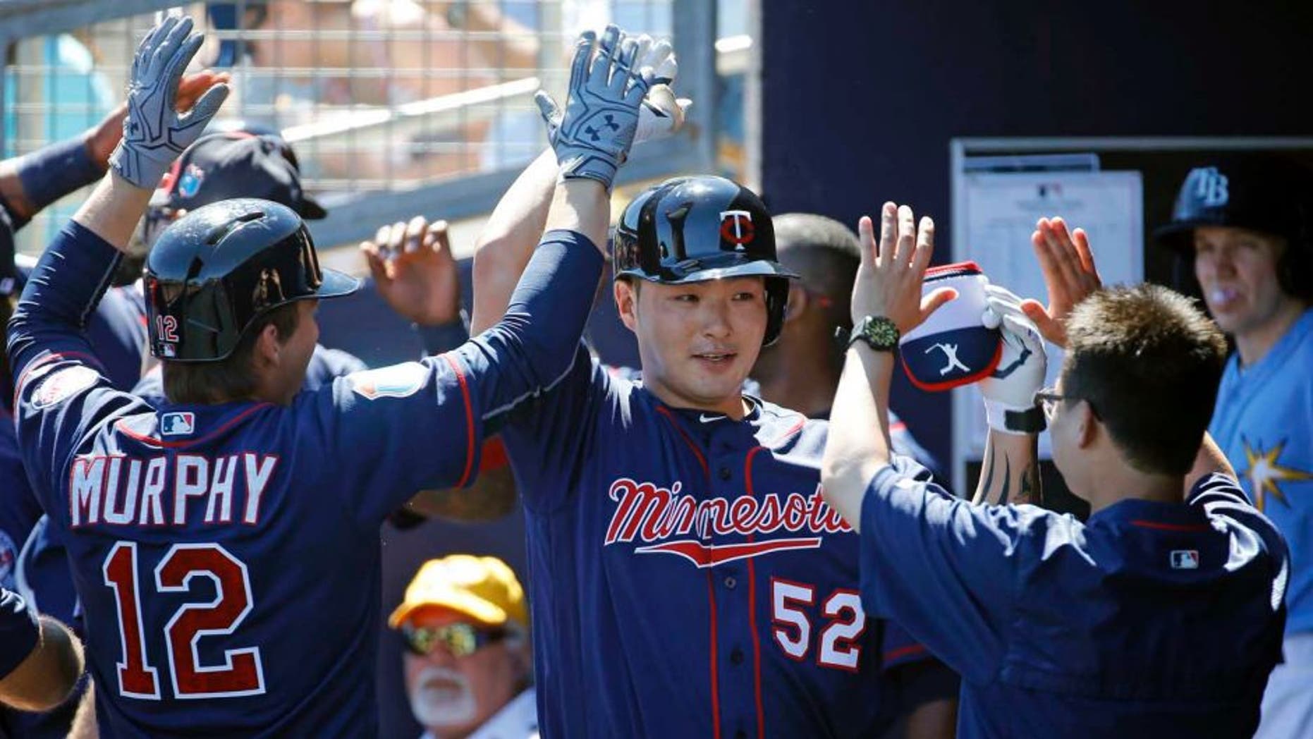 The Minnesota Twins' Byung Ho Park (center) high-fives teammates in the dugout after hitting a grand slam in the first inning of a spring training game against the Tampa Bay Rays in Port Charlotte, Fla., on Sunday, March 6, 2016.