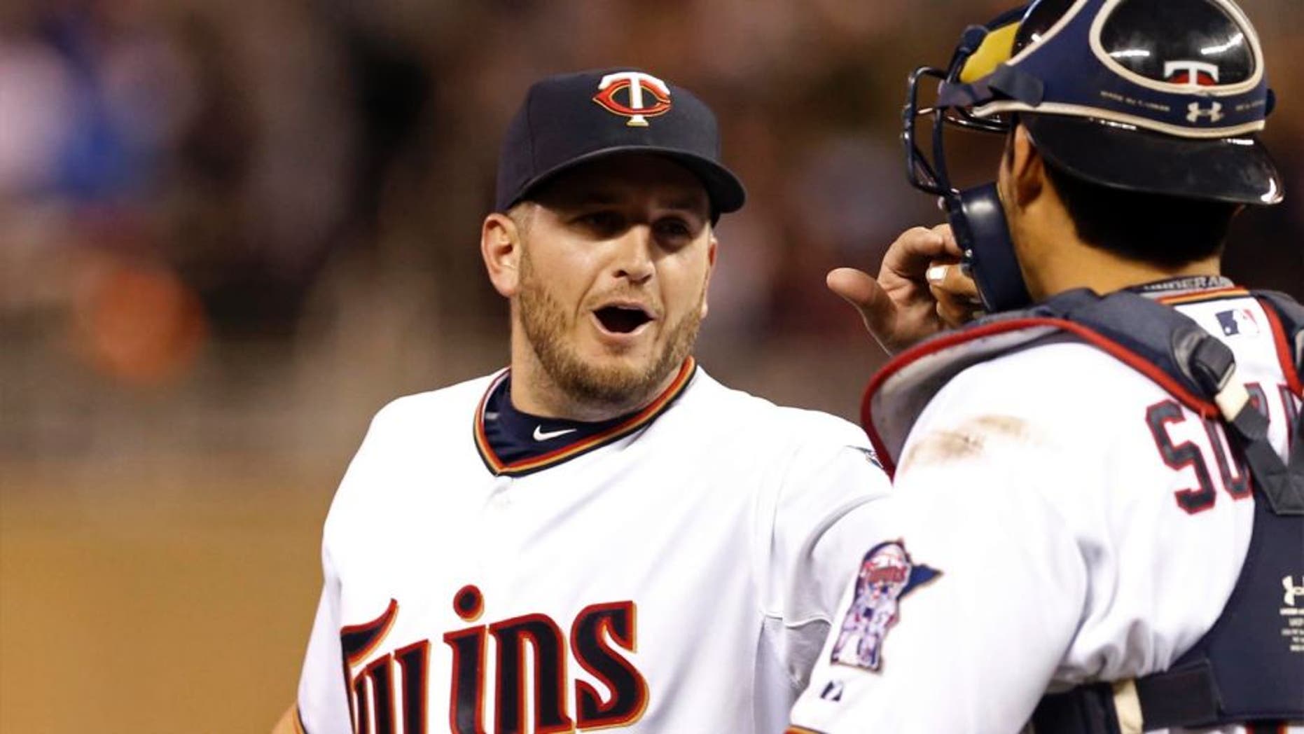 Minnesota Twins pitcher Glen Perkins (left) and catcher Kurt Suzuki celebrate the Twins' 8-7 win over the Oakland Athletics on Monday, May 4, 2015, in Minneapolis.