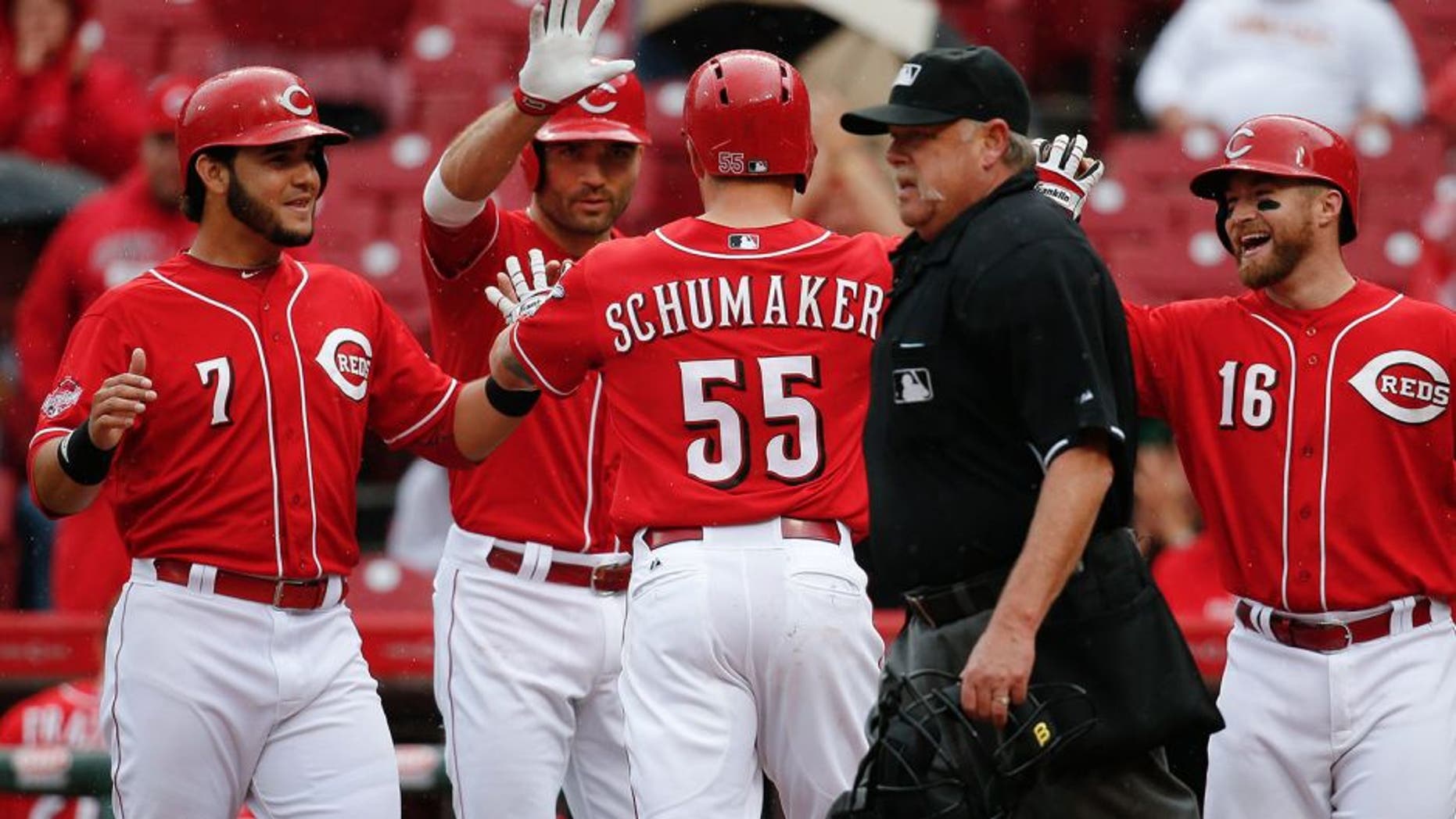 Cincinnati Reds' Skip Schumaker (55) celebrates his three-run home run off St. Louis Cardinals starting pitcher Lance Lynn with Eugenio Suarez (7), Joey Votto, center left, and Tucker Barnhart (16) in the fifth inning of a baseball game, Saturday, Sept. 12, 2015, in Cincinnati. (AP Photo/John Minchillo)