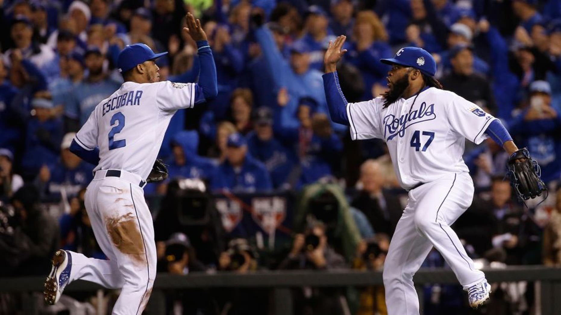 Kansas City Royals pitcher Johnny Cueto (47) celebrates with Alcides Escobar after a ground ended the seventh inning of Game 2 of the Major League Baseball World Series against the New York Mets Wednesday, Oct. 28, 2015, in Kansas City, Mo. (AP Photo/Matt Slocum)