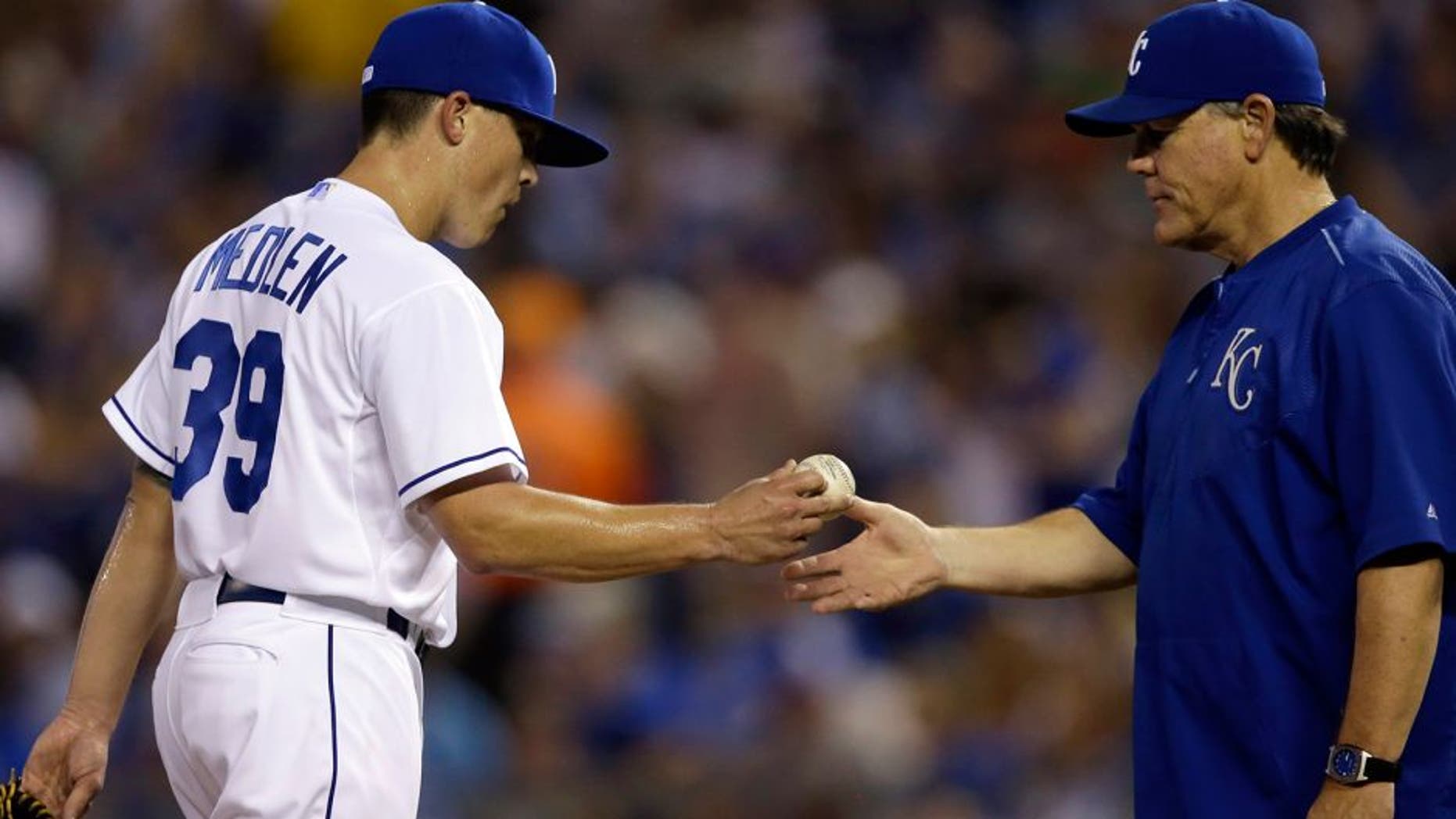 Kansas City Royals starting pitcher Kris Medlen (39) hands the ball to manager Ned Yost, right, during the sixth inning of a baseball game against the Chicago White Sox at Kauffman Stadium in Kansas City, Mo., Friday, Sept. 4, 2015. (AP Photo/Orlin Wagner)