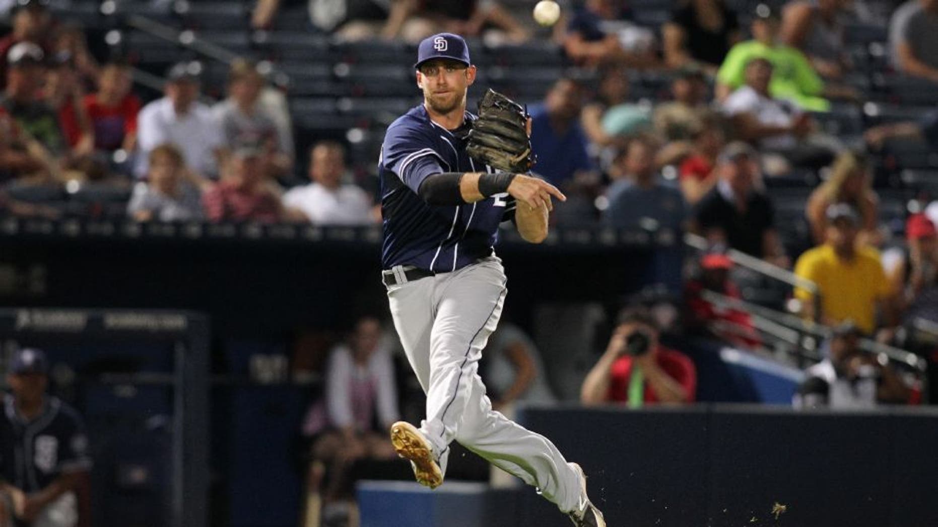 San Diego Padres third baseman Will Middlebrooks (11) throws a runner out at first base against the Atlanta Braves in the tenth inning at Turner Field.