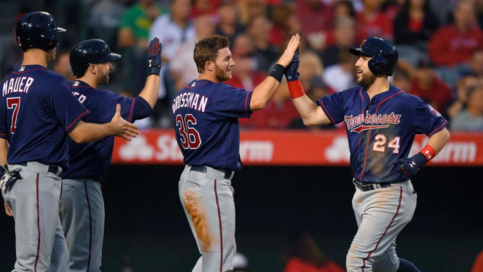 The Minnesota Twins' Trevor Plouffe (right) is congratulated by Joe Mauer (left), Brian Dozier (second from left) and Robbie Grossman after hitting a three-run home run during the third inning against the Los Angeles Angels on Monday, June 13, 2016, in Anaheim, Calif.