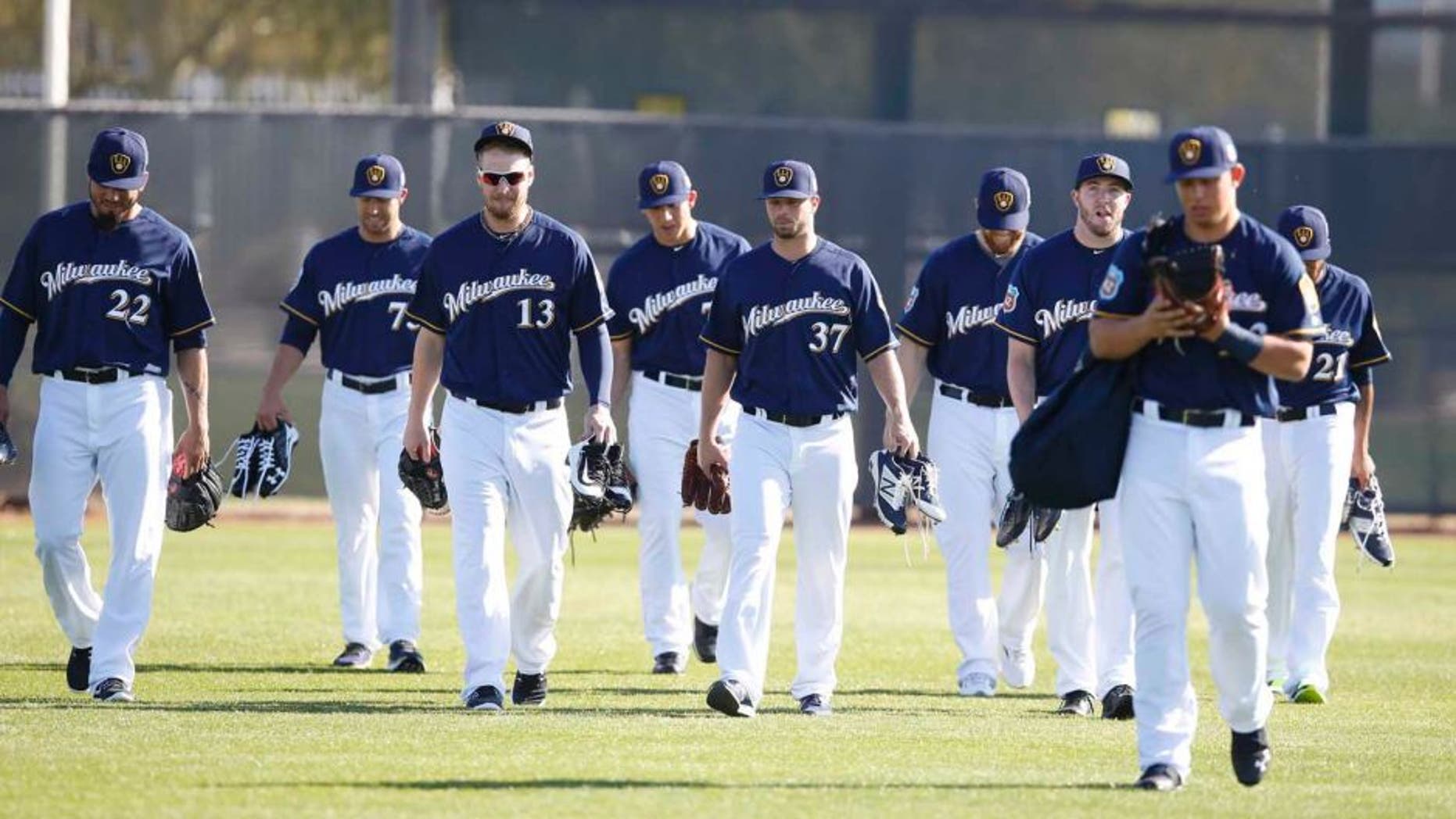 Milwaukee Brewers pitchers and catchers walk on the field during spring training camp at Maryvale Baseball Park in Maryvale, Ariz., on Sunday, Feb. 21, 2016.