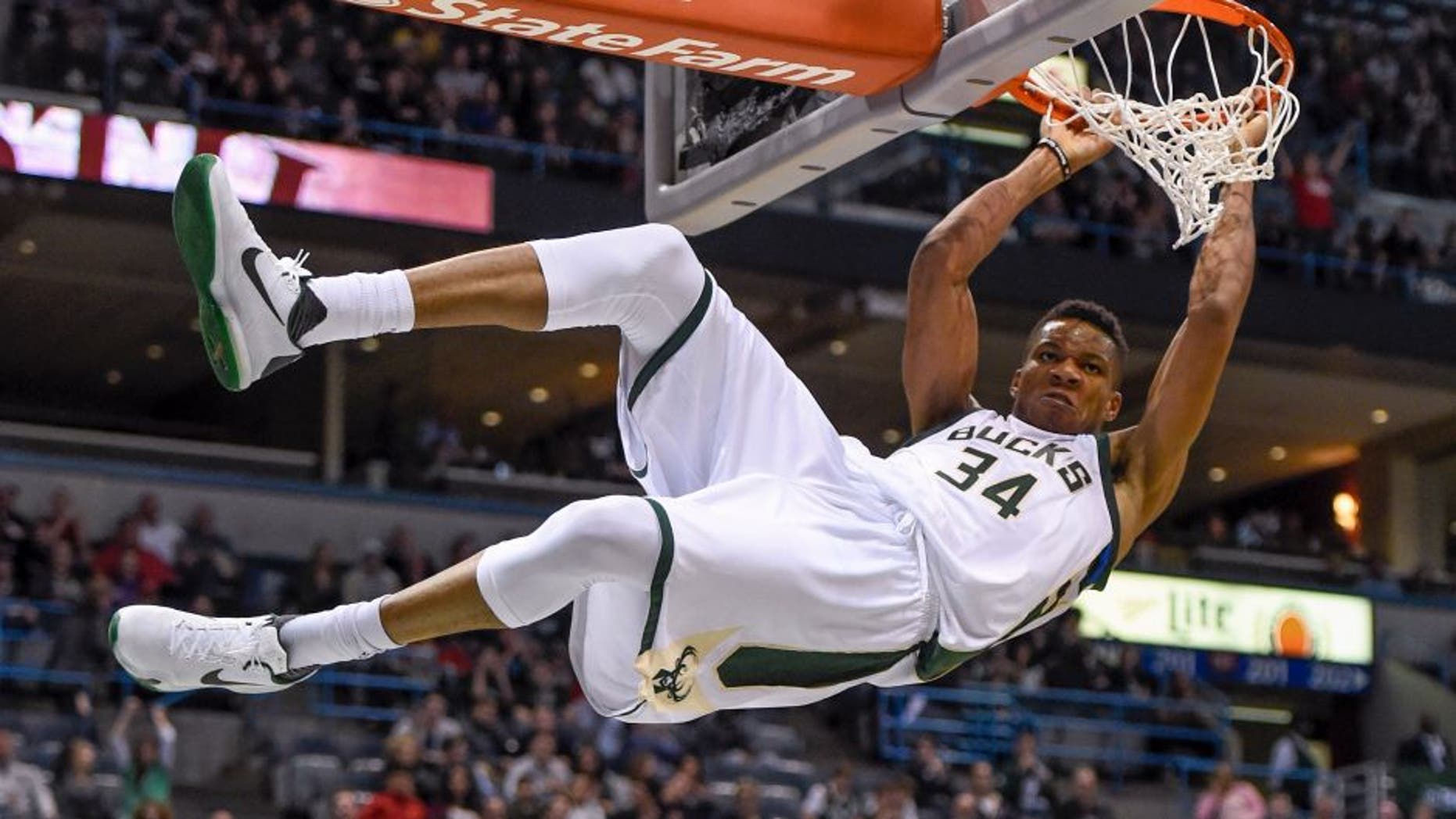 Nov 5, 2016; Milwaukee, WI, USA; Milwaukee Bucks forward Giannis Antetokounmpo (34) hangs onto the rim after dunking for a basket in the third quarter during the game against the Sacramento Kings at BMO Harris Bradley Center. The Bucks beat the Kings 117-91. Mandatory Credit: Benny Sieu-USA TODAY Sports
