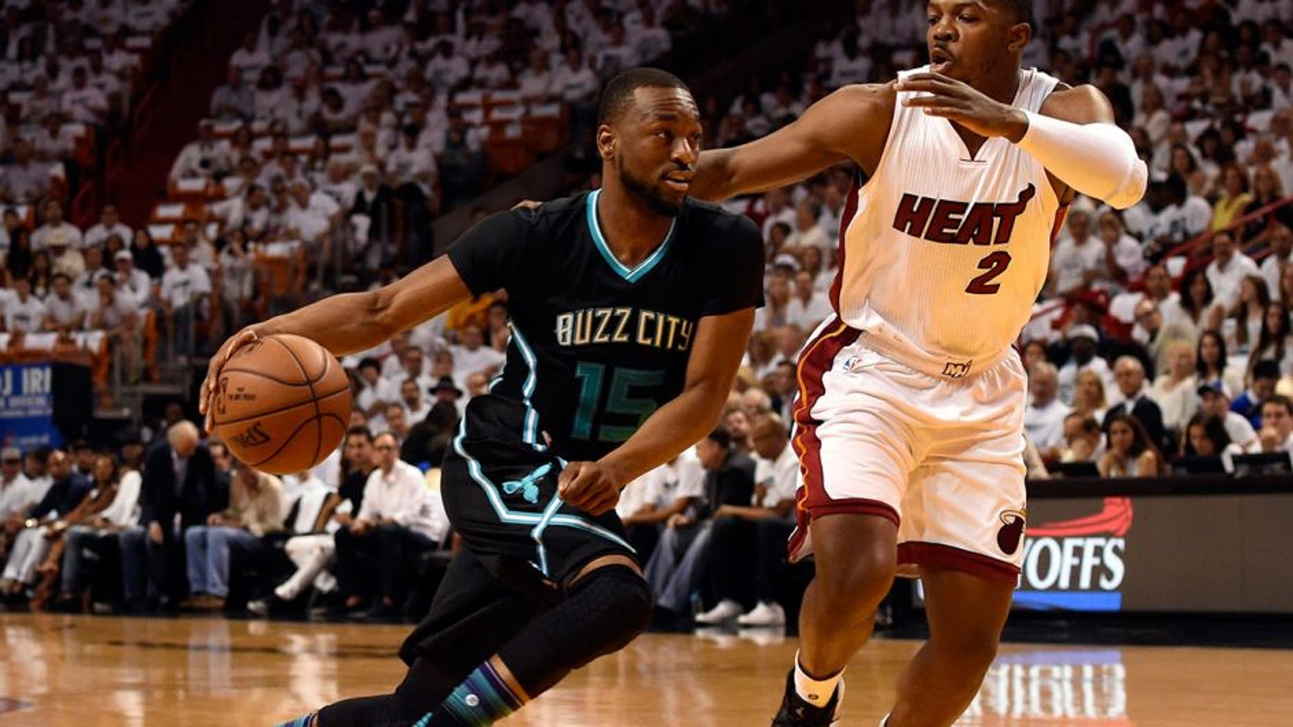 May 1, 2016; Miami, FL, USA; Charlotte Hornets guard Kemba Walker (15) drives to the basket as Miami Heat forward Joe Johnson (2) defends during the first half in game seven of the first round of the NBA Playoffs at American Airlines Arena. Mandatory Credit: Steve Mitchell-USA TODAY Sports